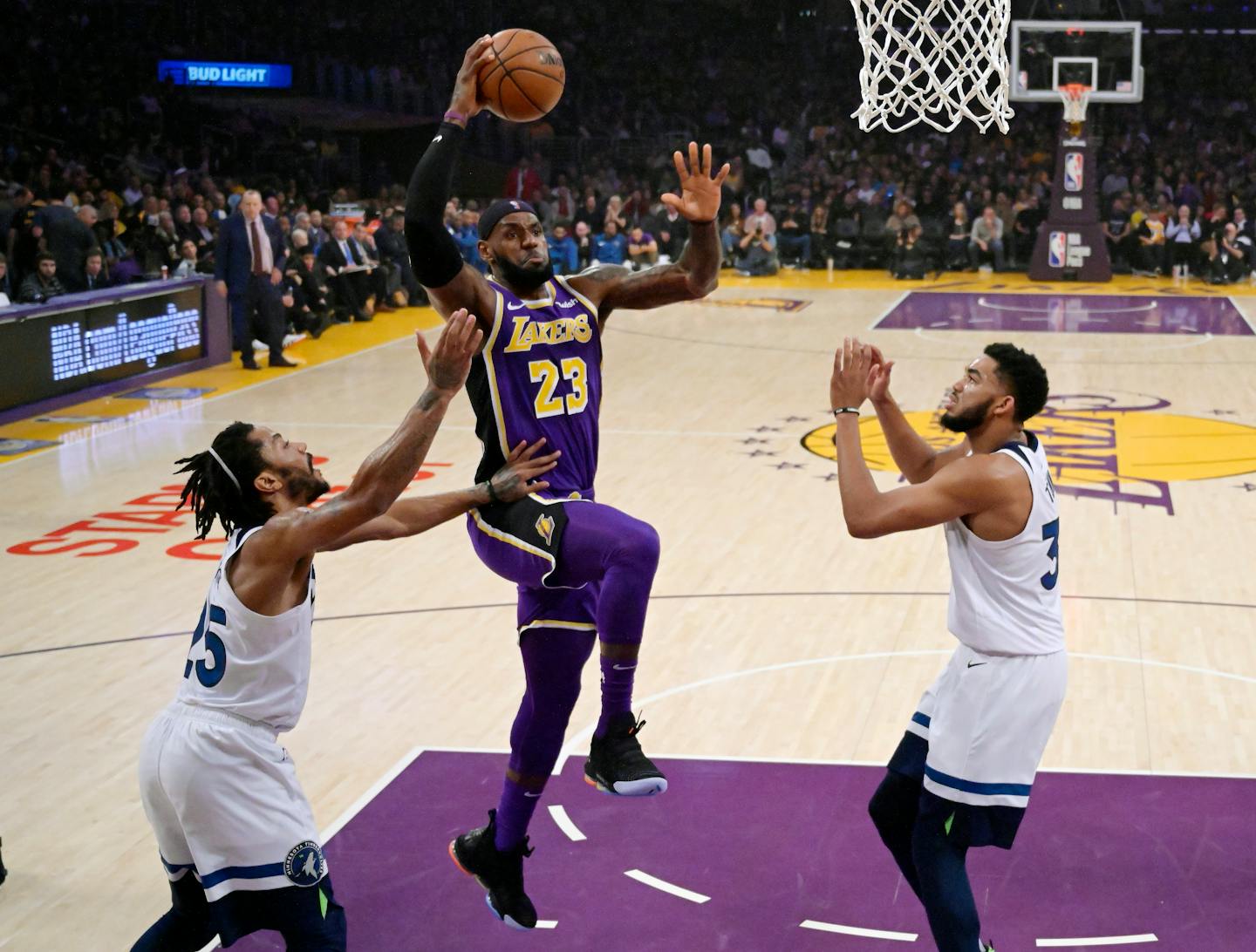 Lakers forward LeBron James, center, shoots as Timberwolves guard Derrick Rose, left, and center Karl-Anthony Towns defend Wednesday at Staples Center.