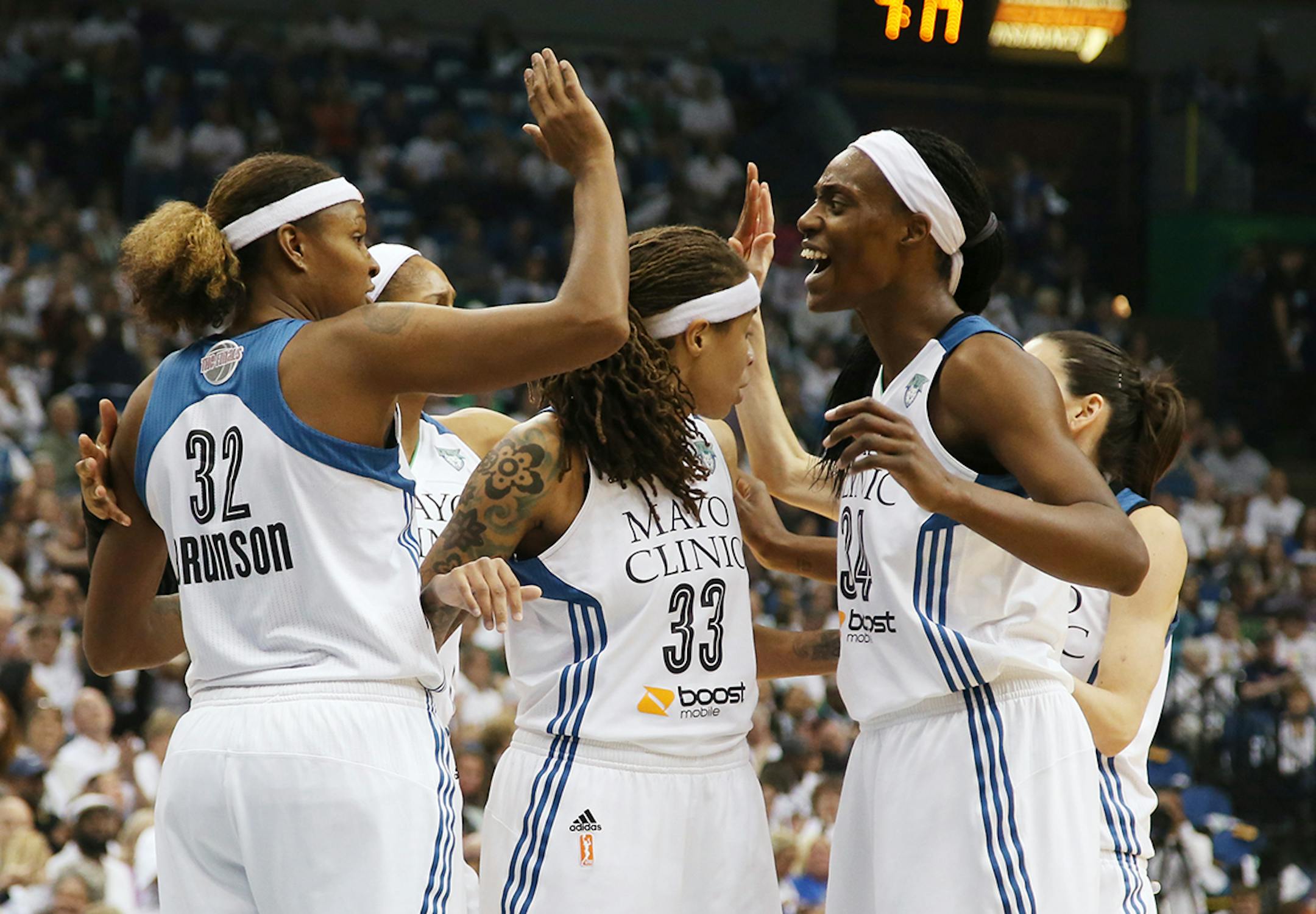 Minnesota Lynx players celebrate during the first half. From left is Minnesota Lynx forward Rebekkah Brunson (32), Minnesota Lynx guard Seimone Augustus (33), and Minnesota Lynx center Sylvia Fowles (34).