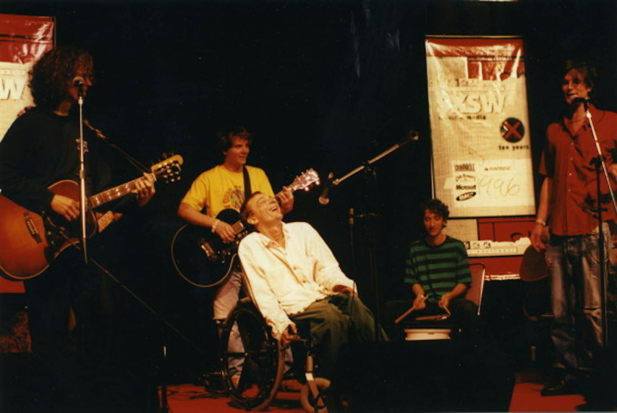 Vic Chesnutt performed at SXSW in 1996 with a few of his local admirers: (from left) Gary Louris, wannabe-Minnesotan Jeff Tweedy, Noah Levy and Kraig Johnson. / Photo by Tim Campbell