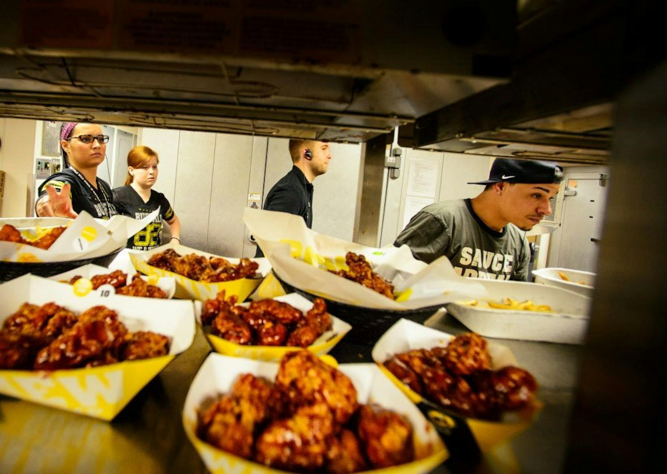 FILE -- The kitchen crew kept meals flowing to customers during lunchtime at the Buffalo Wild Wings at the University of Minnesota on March 20, 2014.