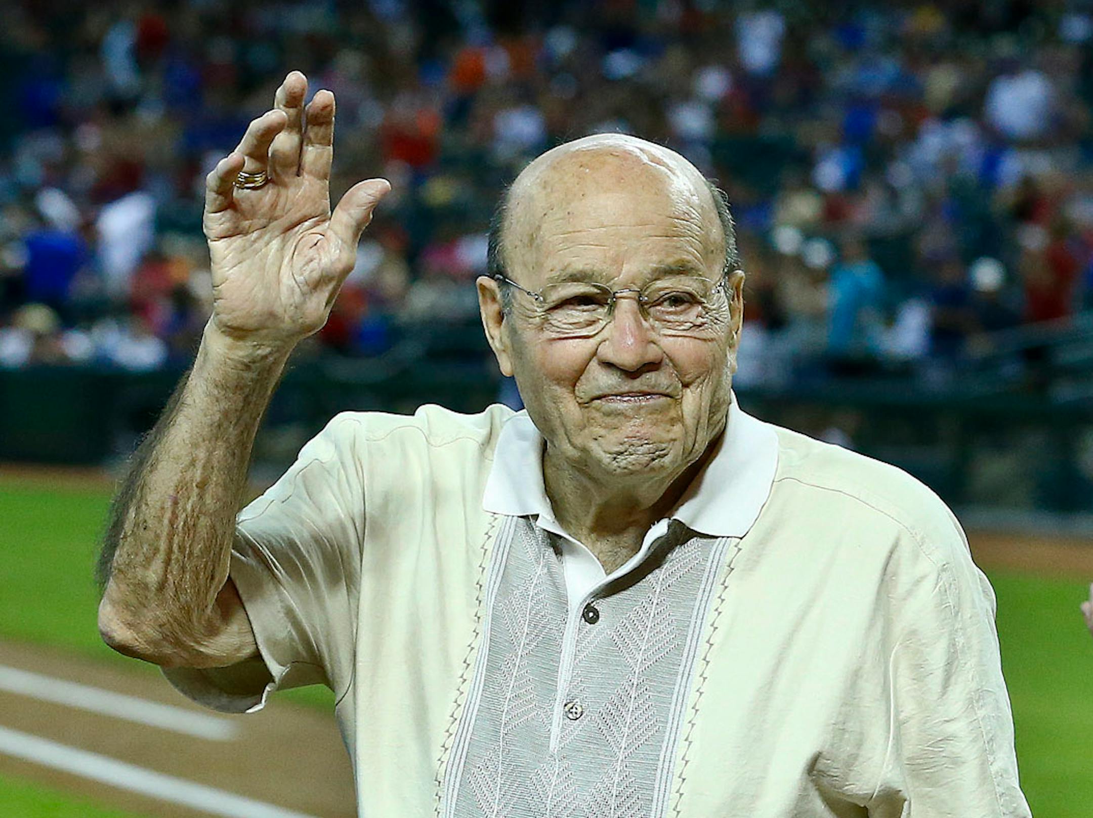 In this April 14, 2013, file photo, Joe Garagiola waved to a cheering crowd during festivities honoring the retiring broadcaster prior to a baseball game against the Dodgers in Phoenix. The former big league catcher and popular broadcaster died Wednesday. He was 90.