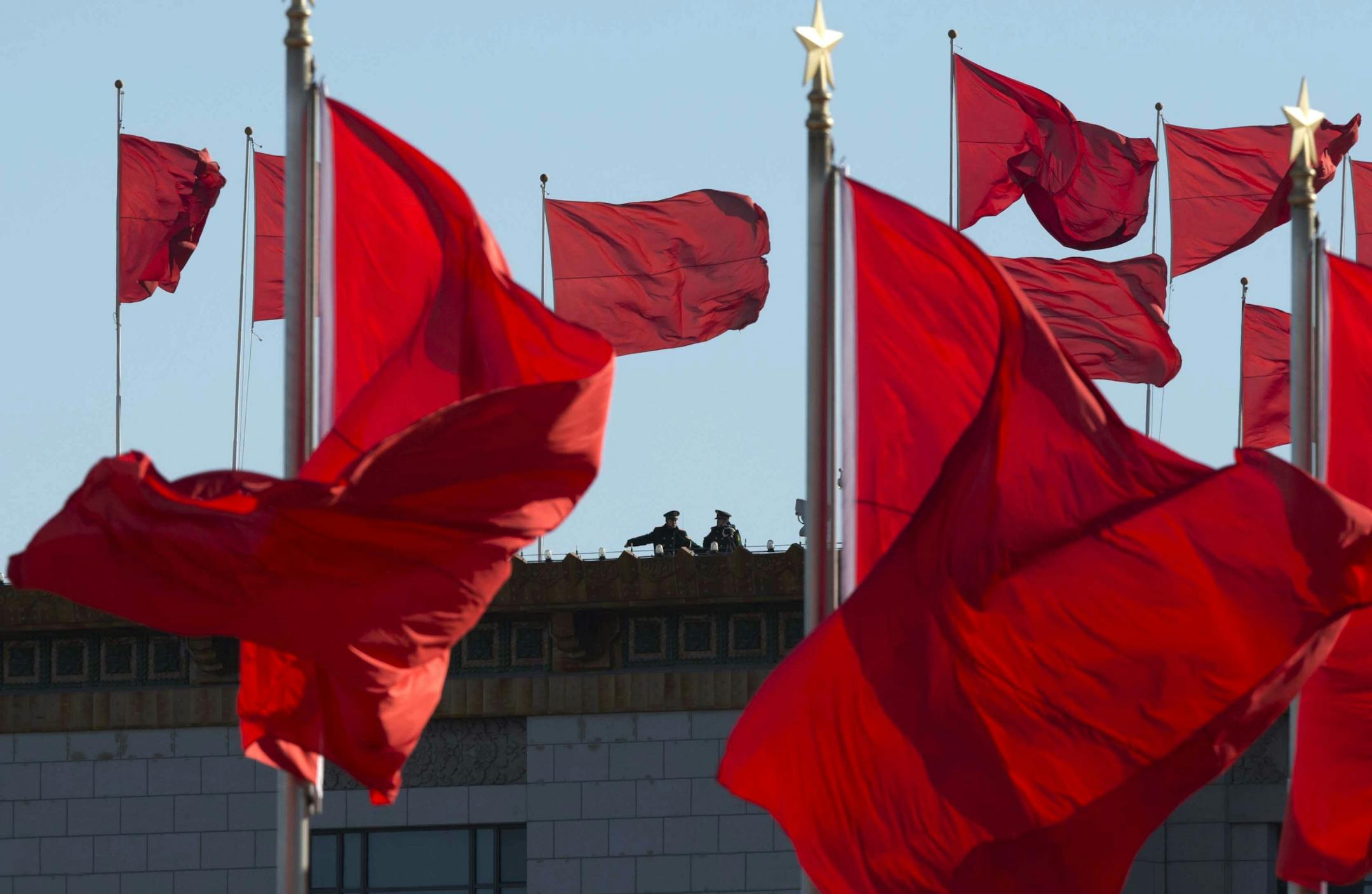 Chinese military personnel watch over Tiananmen Square from a rooftop across from the Great Hall of the People in Beijing onMarch 4, 2013.