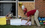 Ben Sunderlin placed a sign of support near the window that was damaged during Saturday morning's attack at the Dar Al Farooq Islamic Center in Bloomi