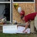 Ben Sunderlin placed a sign of support near the window that was damaged during Saturday morning's attack at the Dar Al Farooq Islamic Center in Bloomi