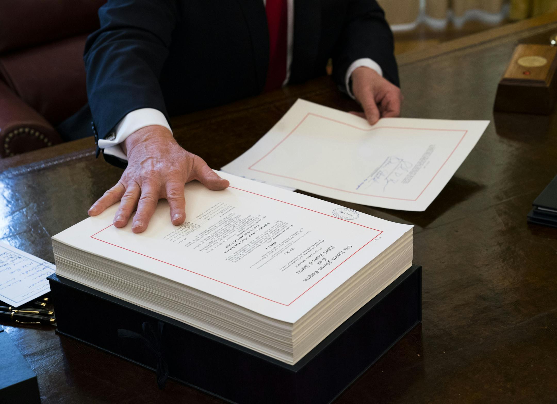 FILE -- President Donald Trump signs the tax reform bill in the Oval Office of the White House in Washington, Dec. 22, 2017. Support for the law ó though not for Trump himself ó is growing even among Democrats, buoying Republican hopes for this yearís congressional elections. (Doug Mills/The New York Times)