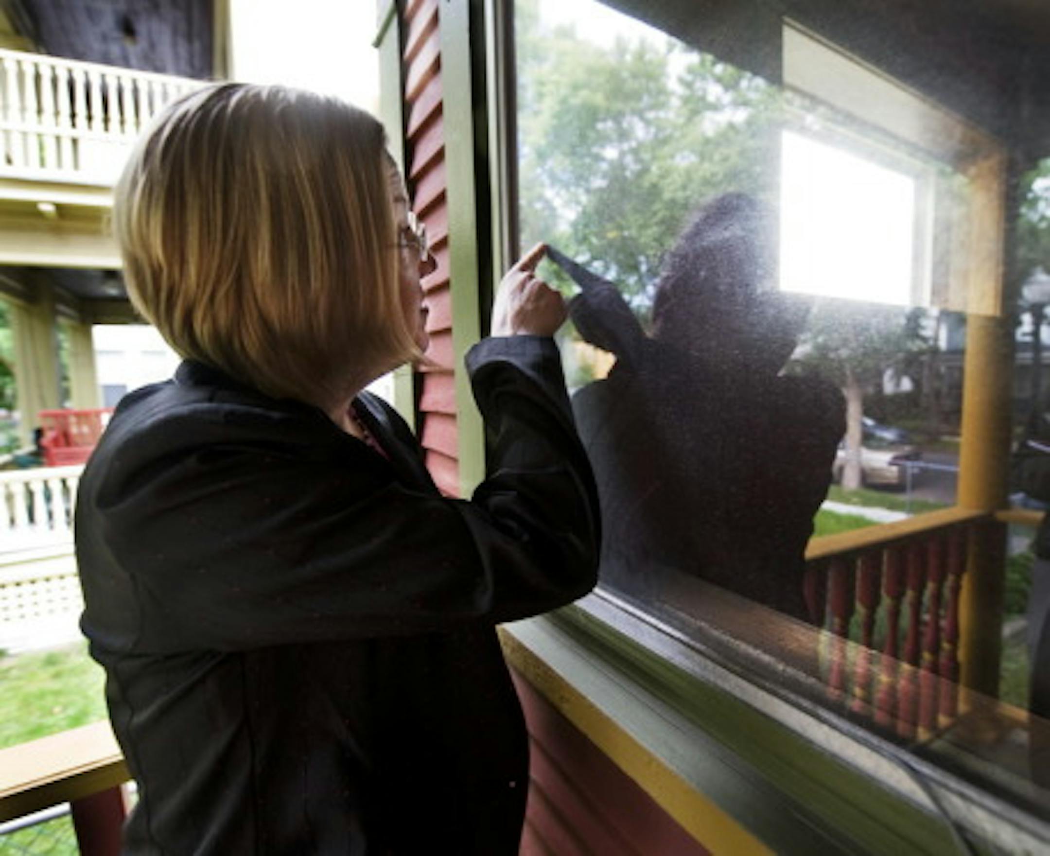 Deneen Clarke at the foreclosed house next door. (Photo by David Brewster)