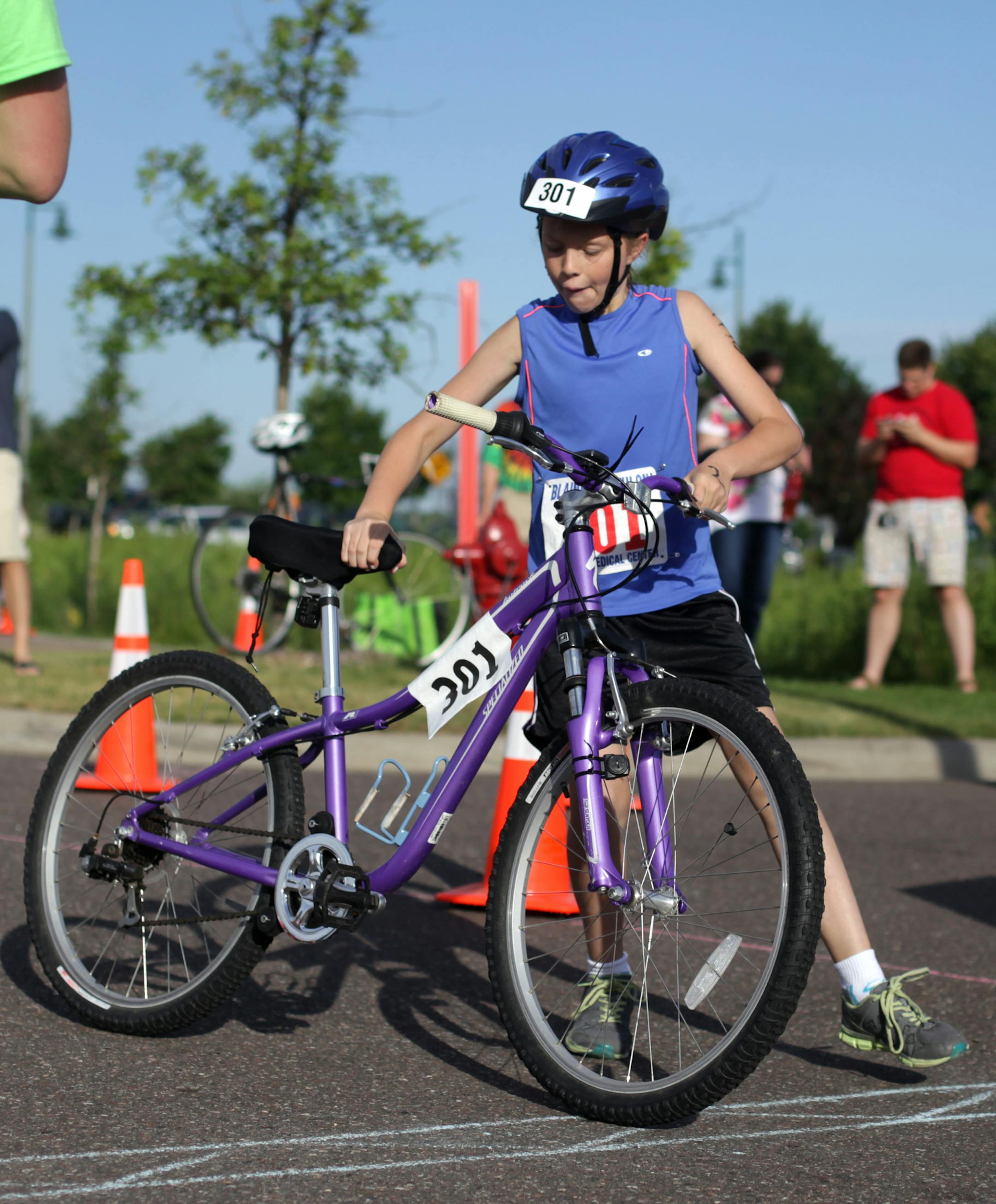 Katherine Mullen,10, hops onto her bike for the cycling portion of the triathlon on Saturday morning. ] Blaine hosted their first Kid's Triathlon on Saturday morning at Lakeside Commons Park. The competitors completed a 165 yard swim, 2.3 mile bike ride, and 1 mile run. MONICA HERNDON monica.herndon@startribune.com Blaine MN 07/26/14