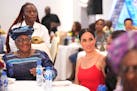 Meghan, the Duchess of Sussex, right, sits by Ngozi Okonjo-Iweala, Director-General of the World Trade Organization, during an event in Abuja, Nigeria