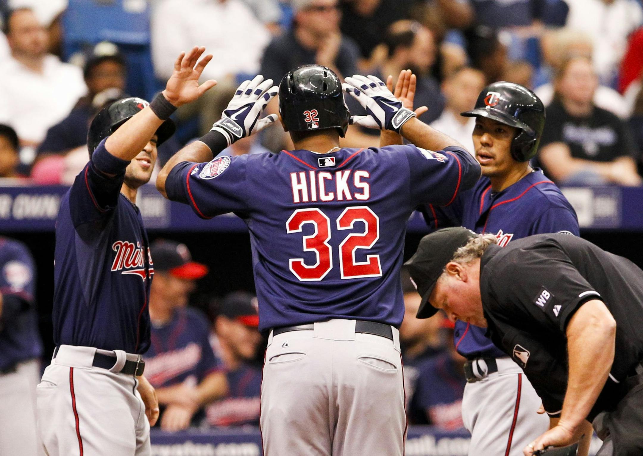 Minnesota Twins center fielder Aaron Hicks (32) gets high-fives from teammates after a three-run homer in the fifth inning during game against the Tampa Bay Rays at Tropicana Field in St. Petersburg, Fla. on Thursday, April 24, 2014. (Will Vragovic/Tampa Bay Times/MCT) ORG XMIT: 1152143