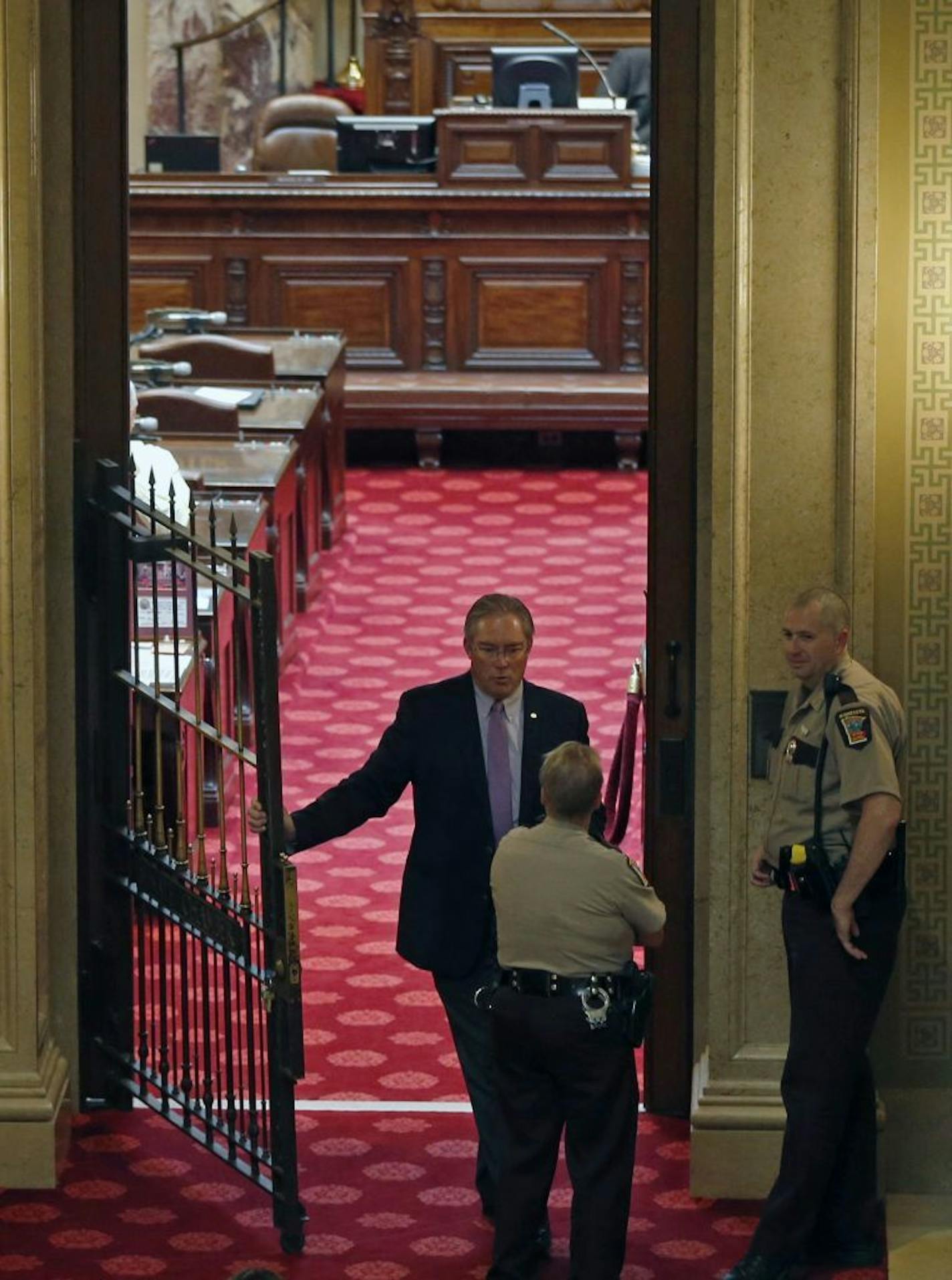 Sergeant-at-Arms Sven K. Lindquist, left, talks with state troopers at the gate to the empty Minnesota Senate chambers during a recess on Day 3 of the special session Thursday, May 25, 2017 in St. Paul, Minn. where lawmakers continue to make another run of passing the major remaining parts of a $46 billion budget.