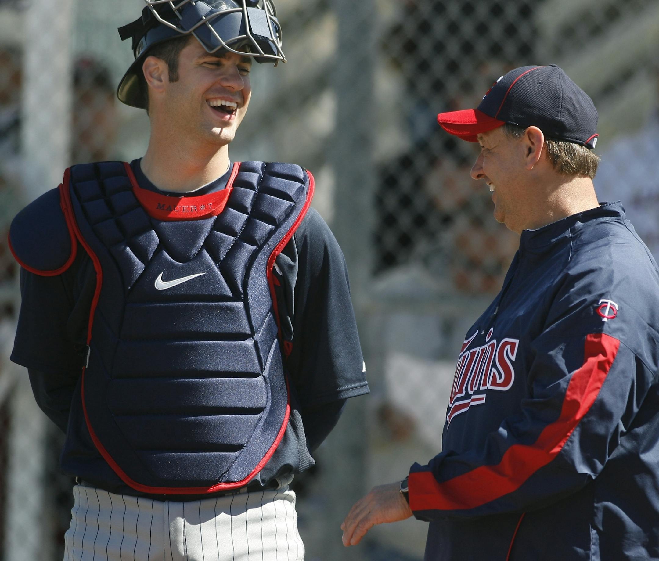 New bench coach Terry Steinbach (right) talks to Joe Mauer at spring training in 2010.