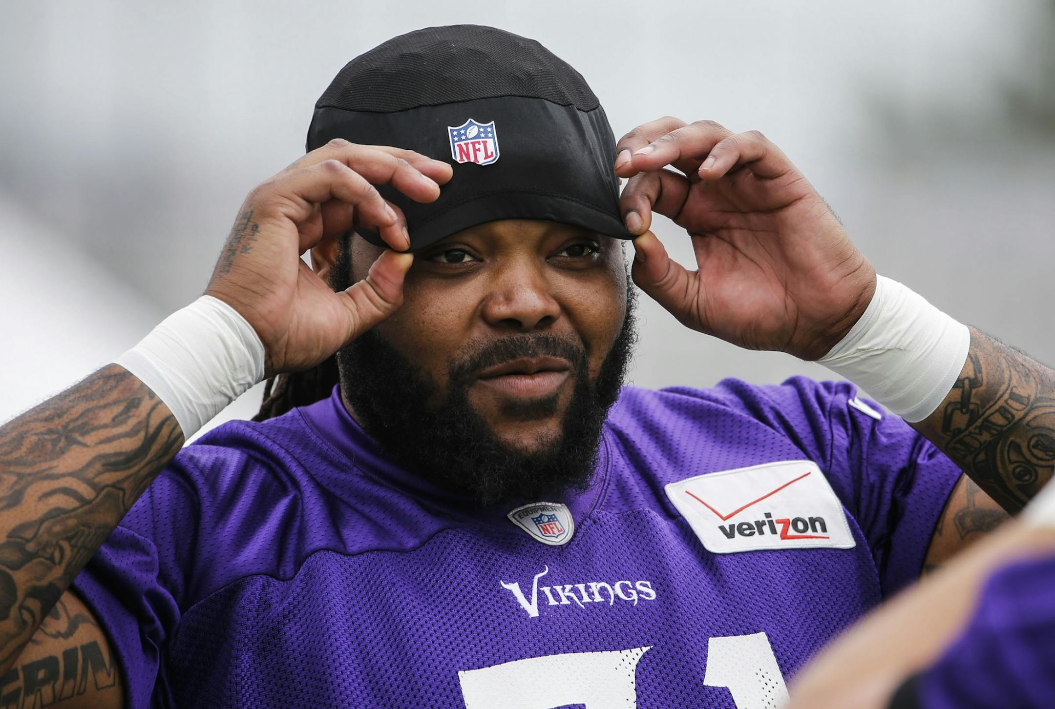 Minnesota Vikings offensive tackle Phil Loadholt adjusts his underhat during the afternoon session of training camp Friday, July 24, 2014, at Mankato State University in Mankato, MN.