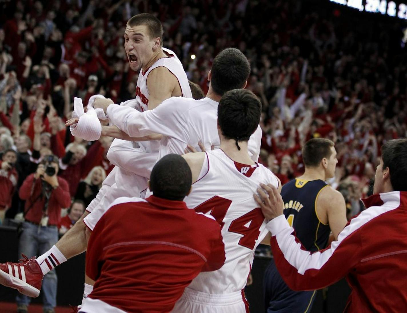 Wisconsin's Ben Brust, top, celebrates after hitting a 3-point shot in the final second of regulation against Michigan.