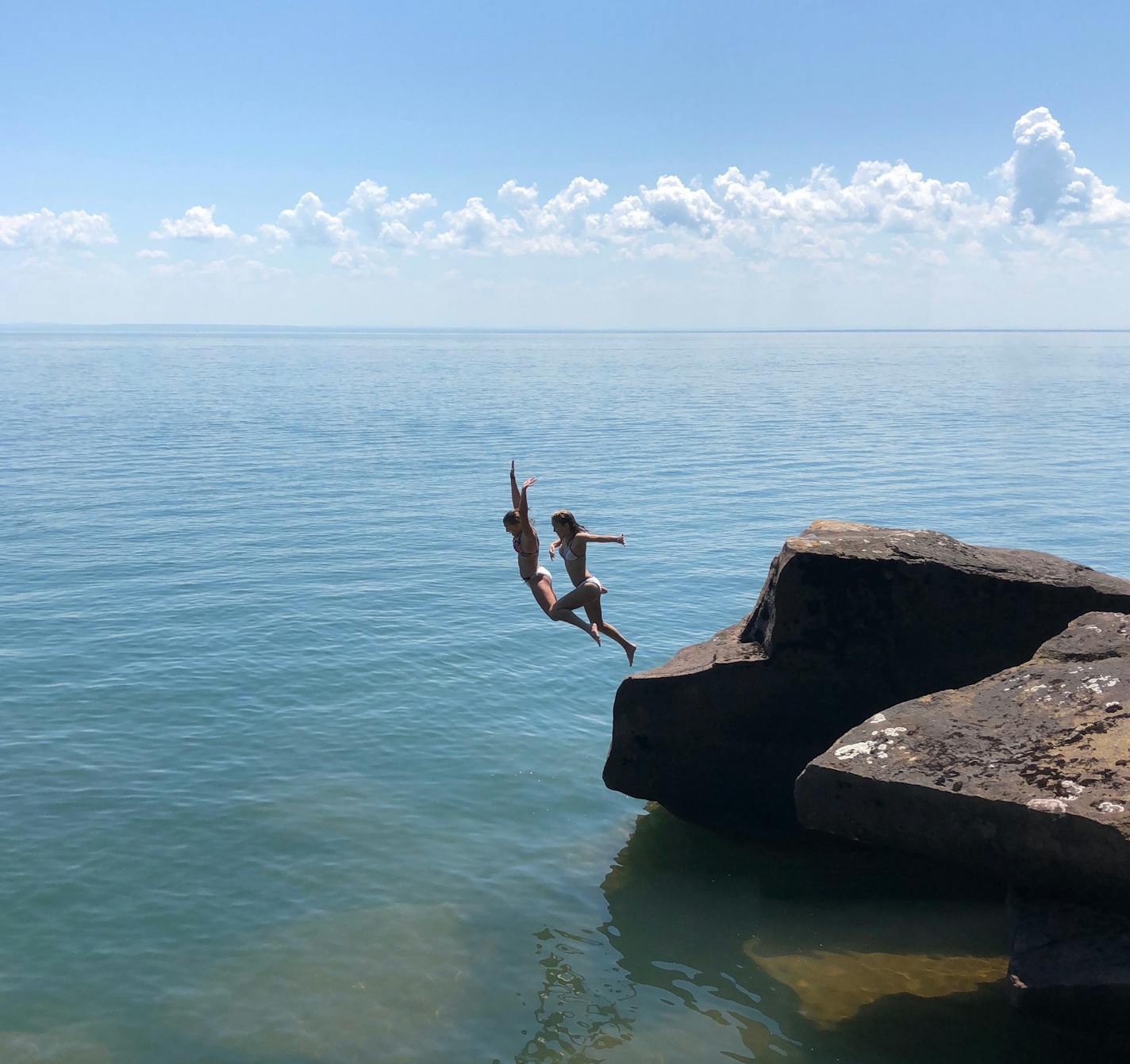 Two girls dive into Lake Superior at Madeline Island's Big Bay State Park. Photo by Martha Sanchez