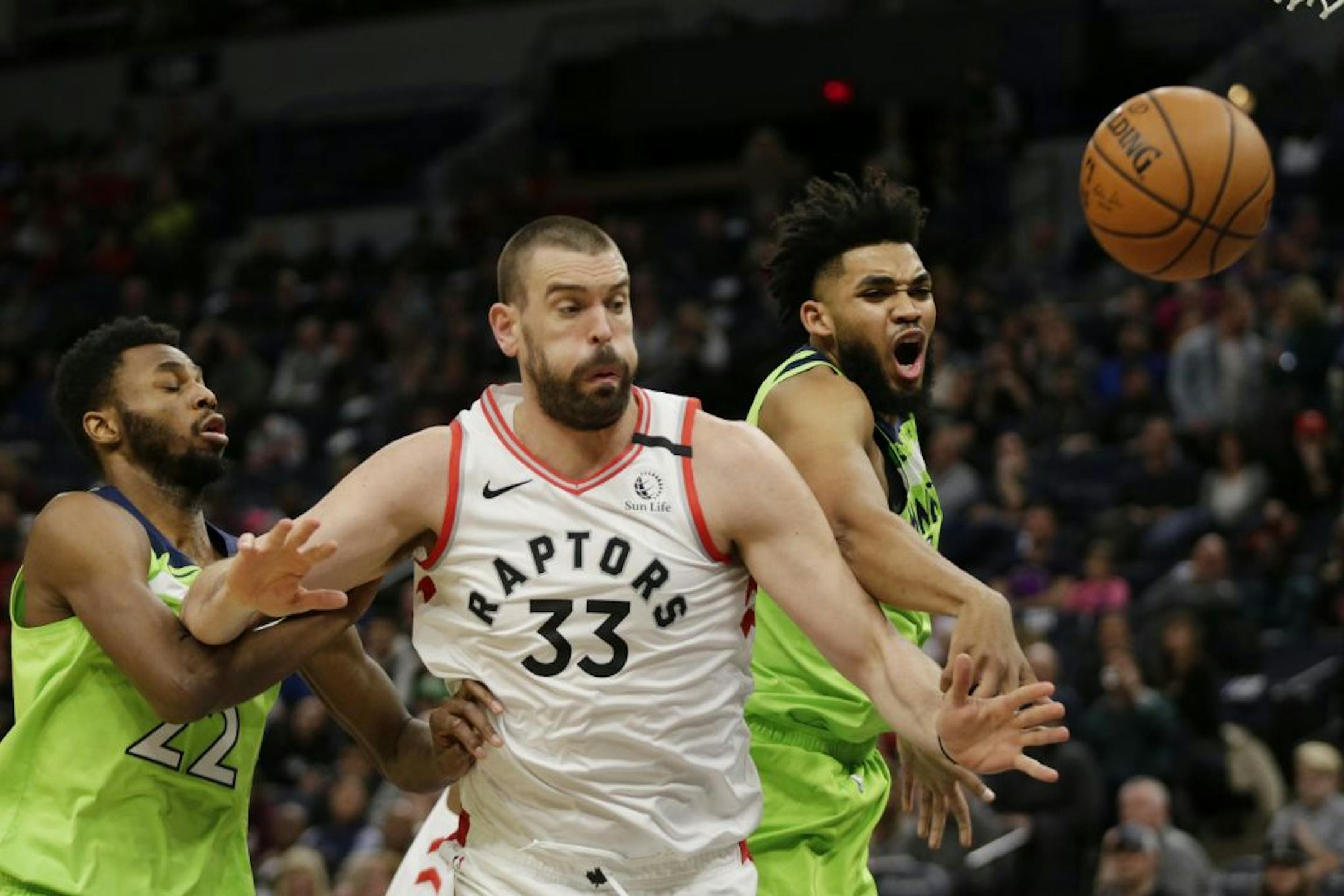 Toronto Raptors Marc Gasol (33) and Minnesota Timberwolves center Karl-Anthony Towns battle for the ball with Timberwolves forward Andrew Wiggins (22) defends in the second quarter of an NBA basketball game Saturday, Jan. 18, 2020, in Minneapolis.