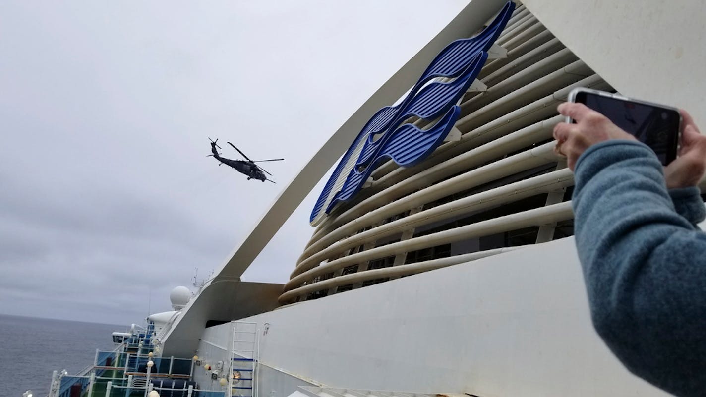 A Coast Guard helicopter delivering virus testing kits hovers above the Grand Princess cruise ship Thursday, March 5, 2020, off the California coast. The unidentified Minnesota patient had been on the Grand Princess for a cruise between California and Mexico, and is recovering at home in isolation.