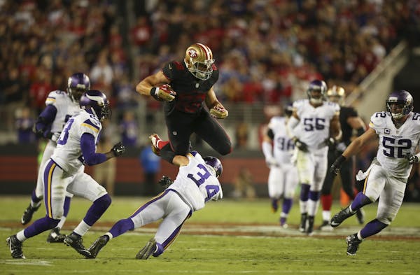 San Francisco 49ers tight end Garrett Celek (88) leapt over Vikings strong safety Andrew Sendejo (34) after catching a short pass for a 20 yaard gain 