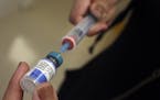 A vial containing the MMR vaccine was loaded into a syringe.