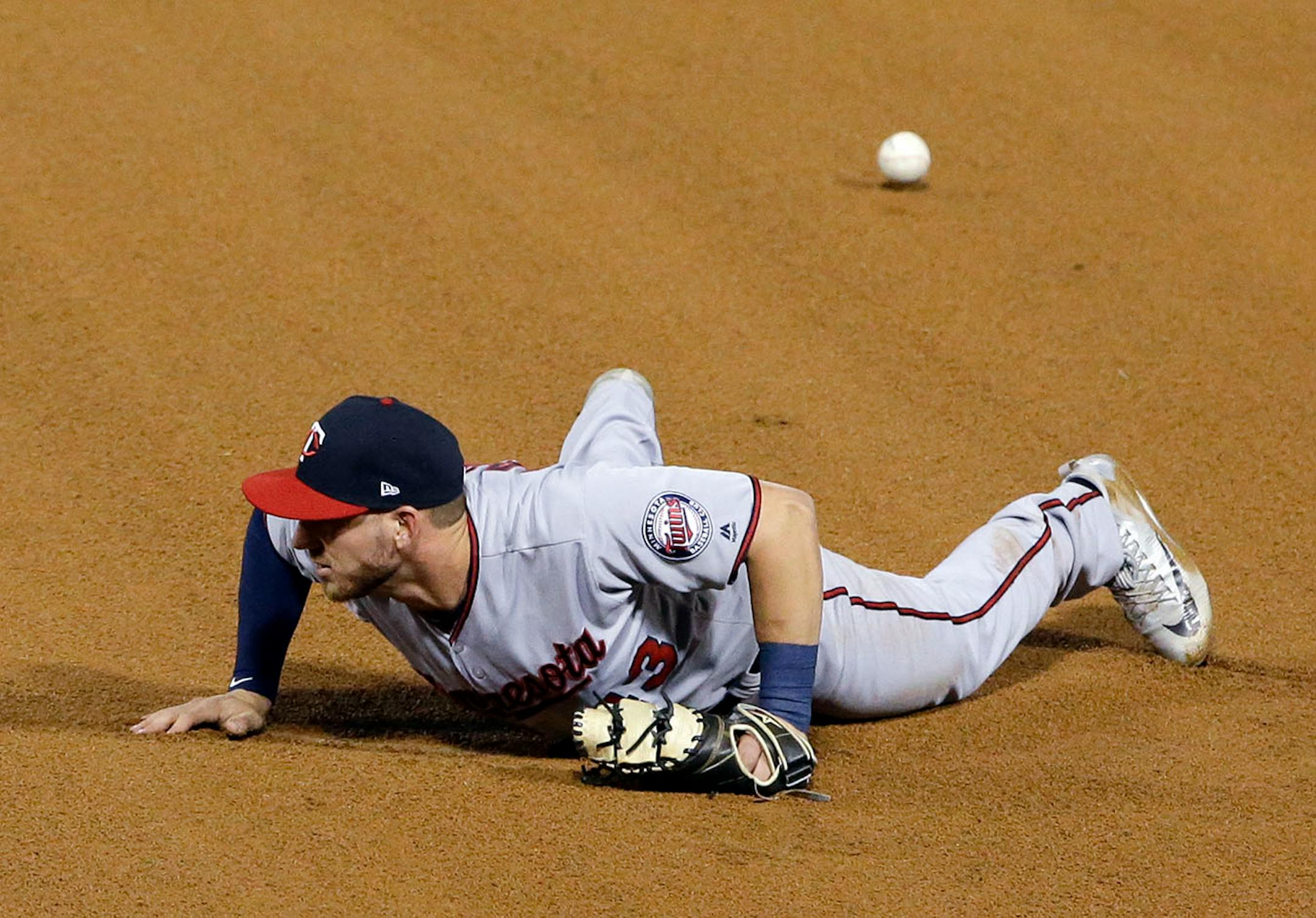Minnesota Twins first baseman Mitch Garver makes a fielding error after Chicago White Sox's Nicky Delmonico hit the ball during the fourth inning of a baseball game Thursday, Aug. 24, 2017, in Chicago.