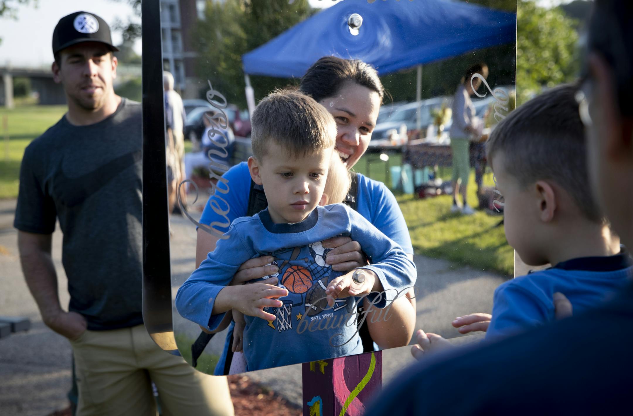 Laura O'Connor held up her son William, 4, to look in a mirror that read "I am beautiful" in Faribault, Minn. on August 22, 2018.
