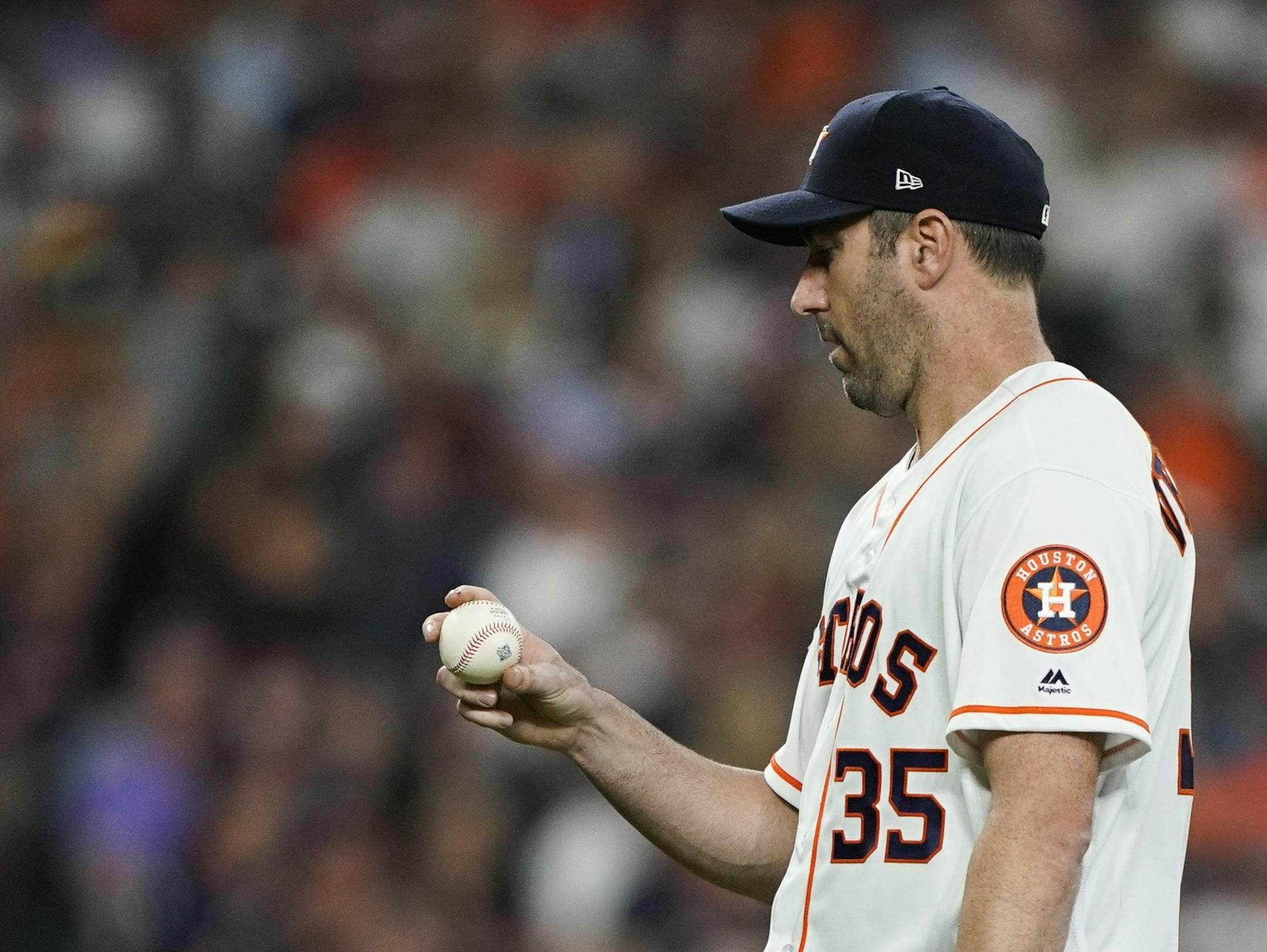 Houston Astros starting pitcher Justin Verlander looks at a ball after giving up a home run to Washington Nationals' Kurt Suzuki during the seventh inning of Game 2 of the baseball World Series Wednesday, Oct. 23, 2019, in Houston. (AP Photo/David J. Phillip) ORG XMIT: WS363