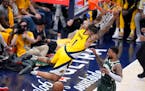 Pacers forward Obi Toppin dunks the ball over Bucks guard Damian Lillard during the second half of Game 6 in Indianapolis on Thursday.
