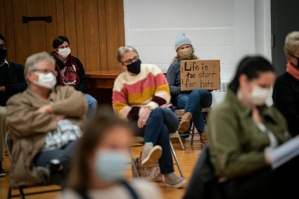 Karen Falk held a sign that reads "Life if too short for hate" during a city council meeting for public discussion on the proposal to grant a permit t