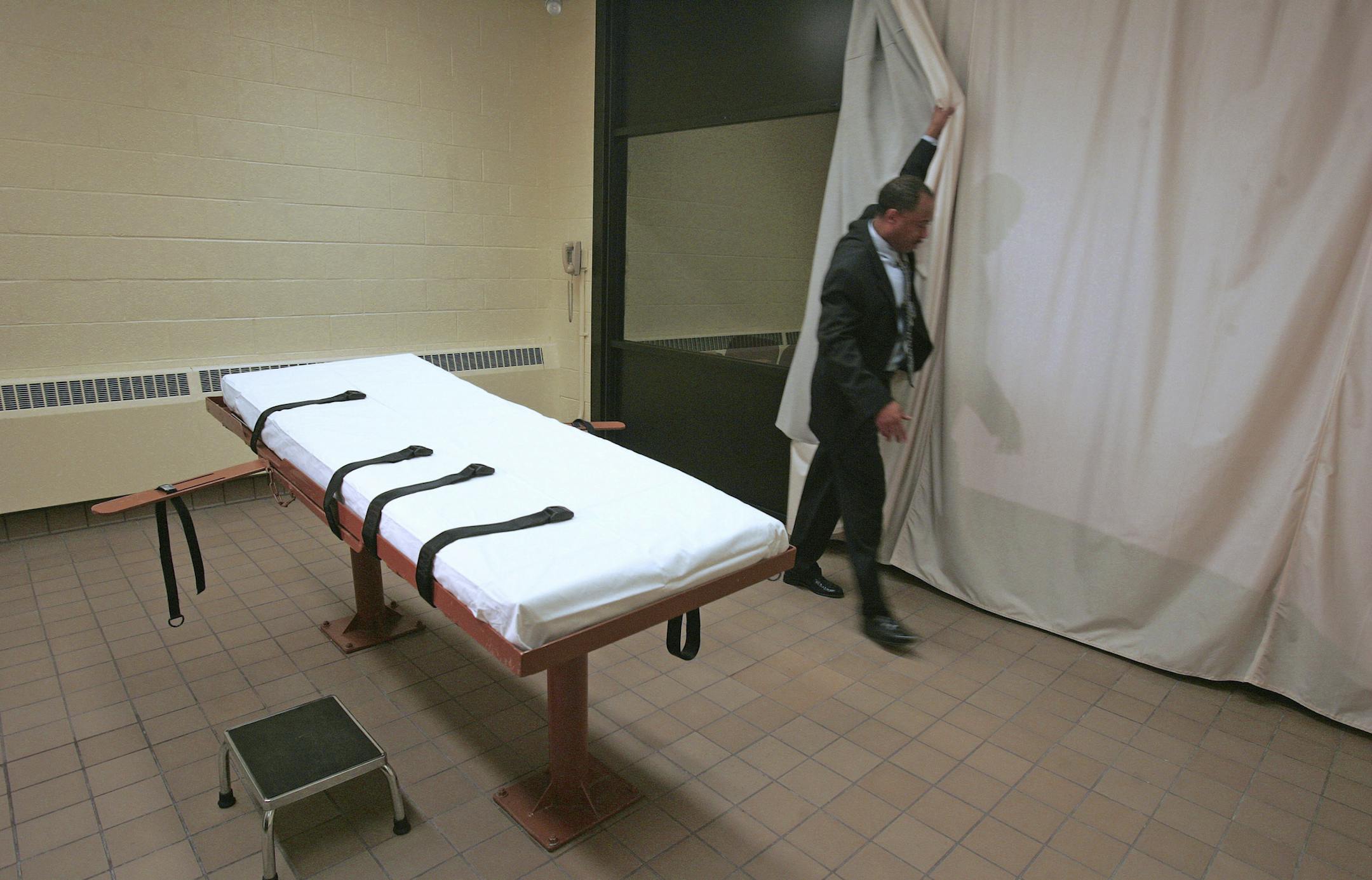 FILE – In this November 2005 file photo, Larry Greene, public information director of the Southern Ohio Correctional Facility, demonstrates how a curtain is pulled between the death chamber and witness room at the prison in Lucasville, Ohio. Defense attorneys rushing to stop Ohio's first execution in three years filed court documents Wednesday, Oct. 26, 2016, arguing the state's new 3-drug lethal injection system is akin to burning inmates at the stake or burying them alive. (AP Photo/Kii