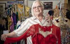 Deborah Nelson, owner of Satin Stitches, posed for a picture holding one of her custom made dance costumes in her store in Coon Rapids.
