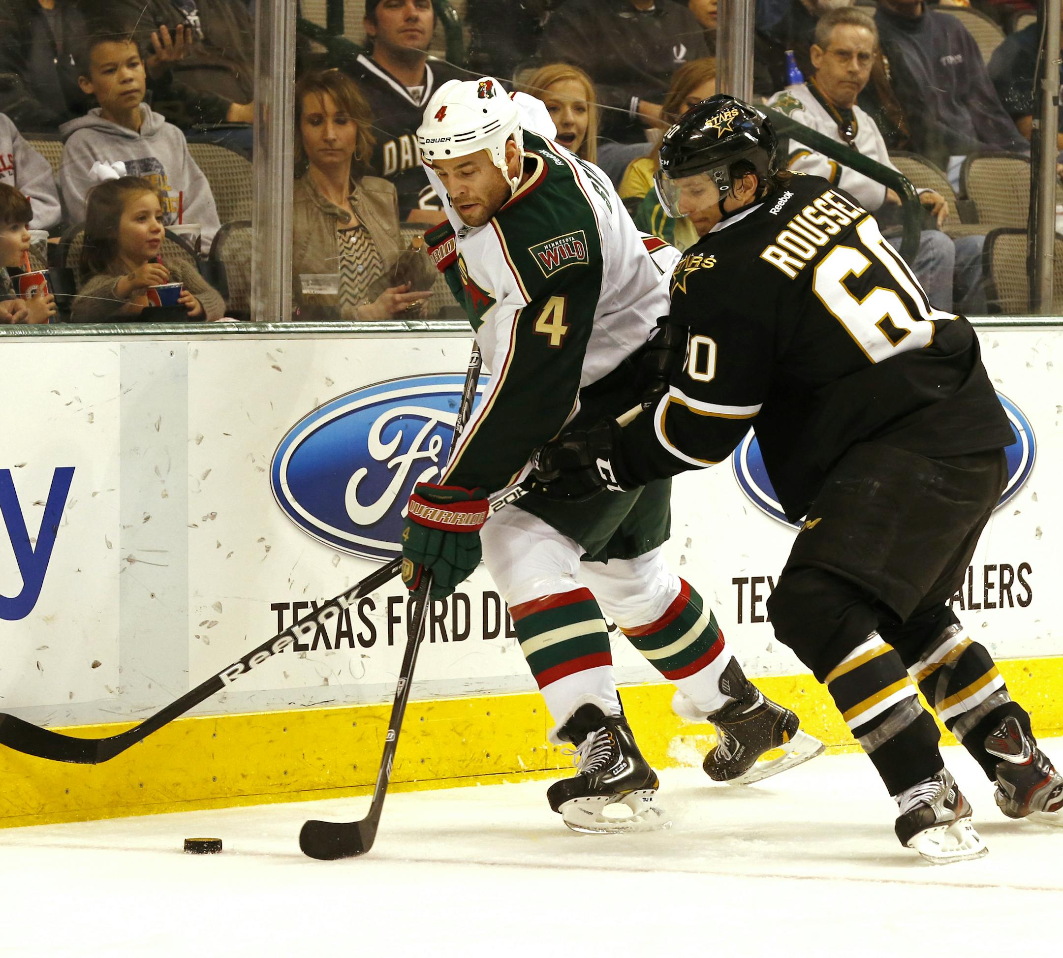 Minnesota Wild defenseman Clayton Stoner,left, (4) and Dallas Stars forward Antoine Roussel (60) fight for the puck during the first period of an NHL hockey game Friday, March 29, 2013, in Dallas, Texas. (AP Photo/Sharon Ellman)