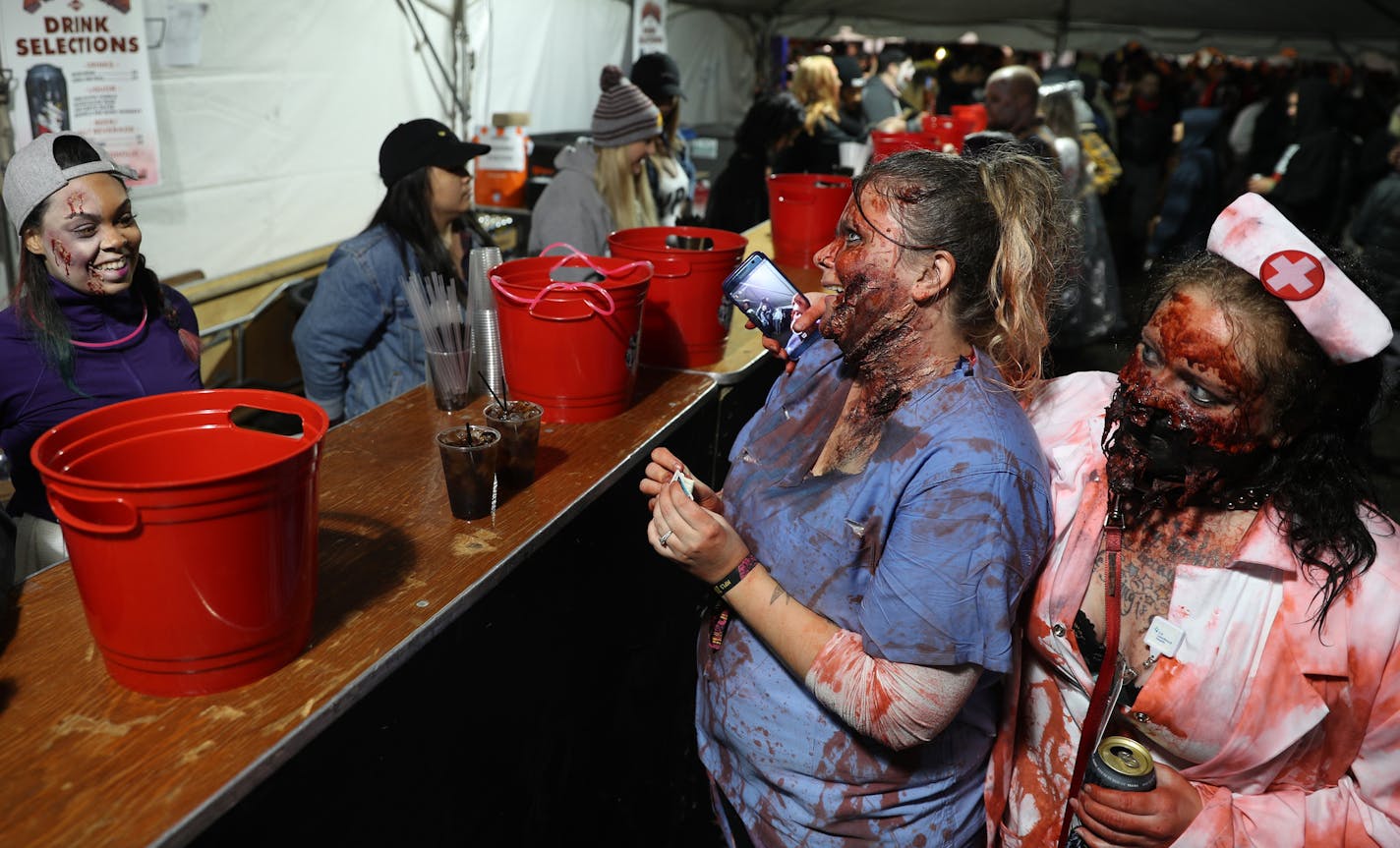 Jamie White, center, and Nikki Rosenfeldt, right, placed their drink orders during the 2017 Zombie Pub Crawl in downtown Minneapolis.