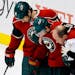 Minnesota Wild defenseman Jared Spurgeon, center, is helped off the ice by trainer Don Fuller, right, and right wing Brad Staubitz (16) during the fir