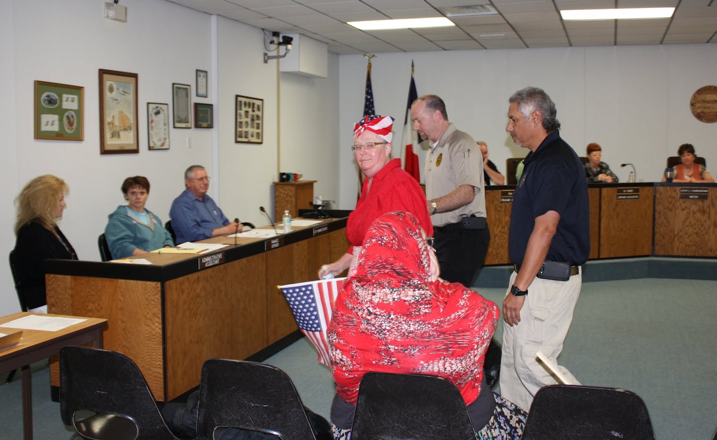 Robin Hensel is escorted out of the Little Falls city council meeting in June 2013.