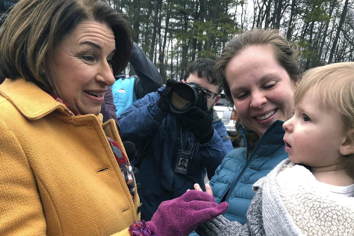 Democratic presidential candidate Sen. Amy Klobuchar, D-Minn., left, greets people outside a New Hampshire primary polling location, Tuesday, Feb. 11, 2020, in Manchester, N.H. (AP Photo/Holly Ramer)