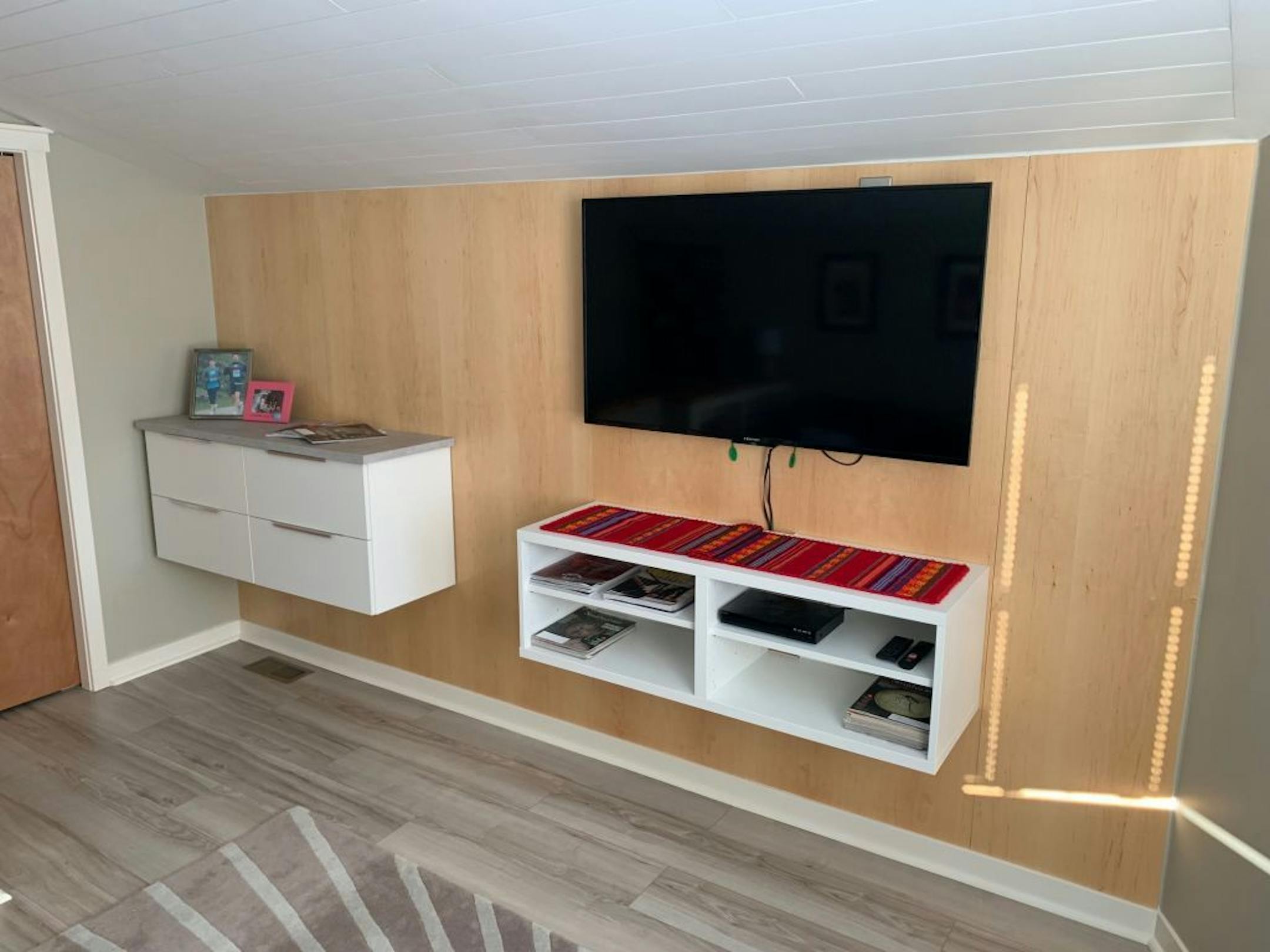 An accent wall of reclaimed wood and floating shelves from Ikea highlight the space.
