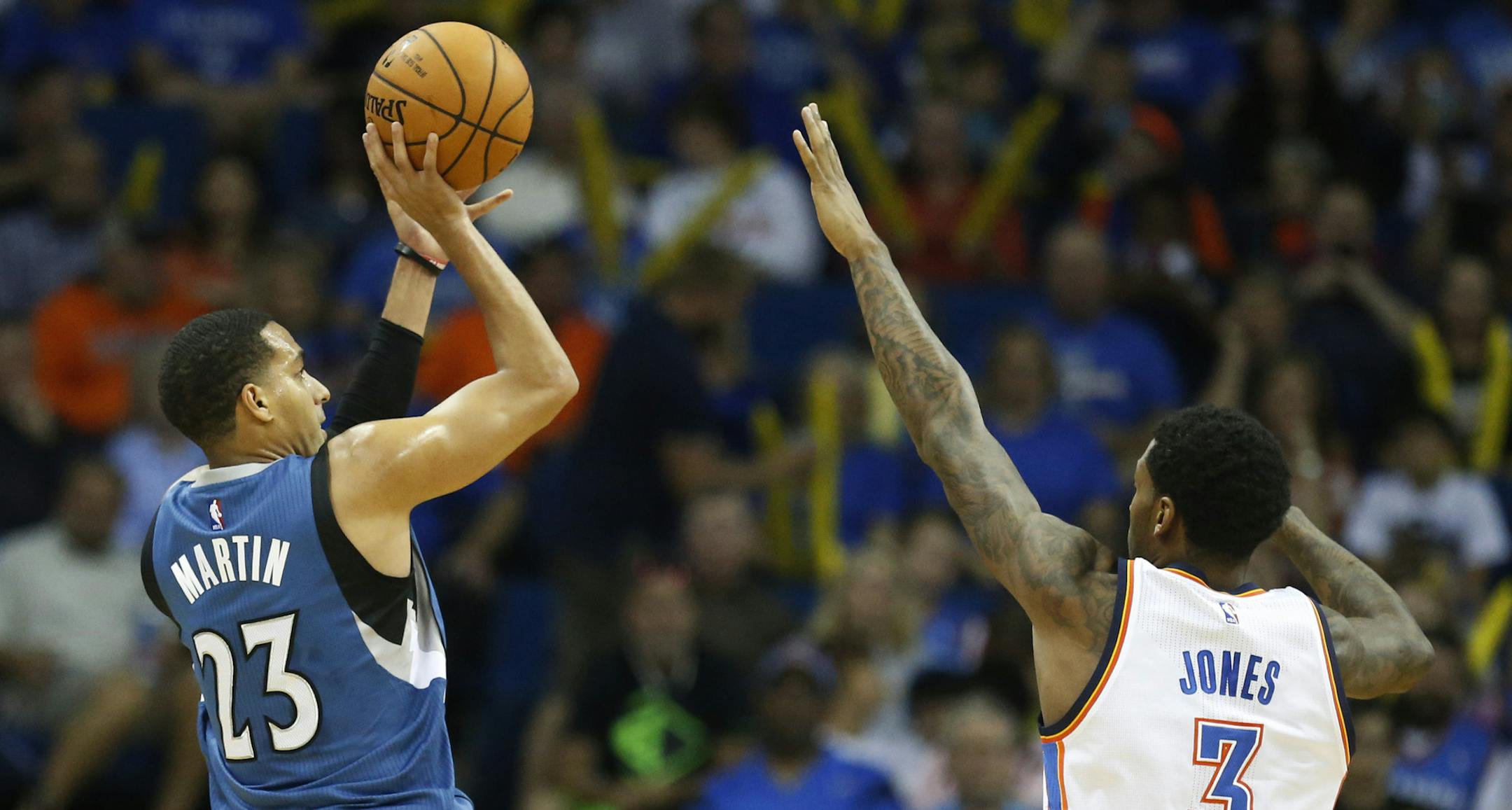 Minnesota Timberwolves guard Kevin Martin (23) shoots over Oklahoma City Thunder forward Perry Jones (3) in the first quarter of an NBA pre-season basketball game in Tulsa, Okla., Sunday, Oct. 19, 2014. (AP Photo/Sue Ogrocki)