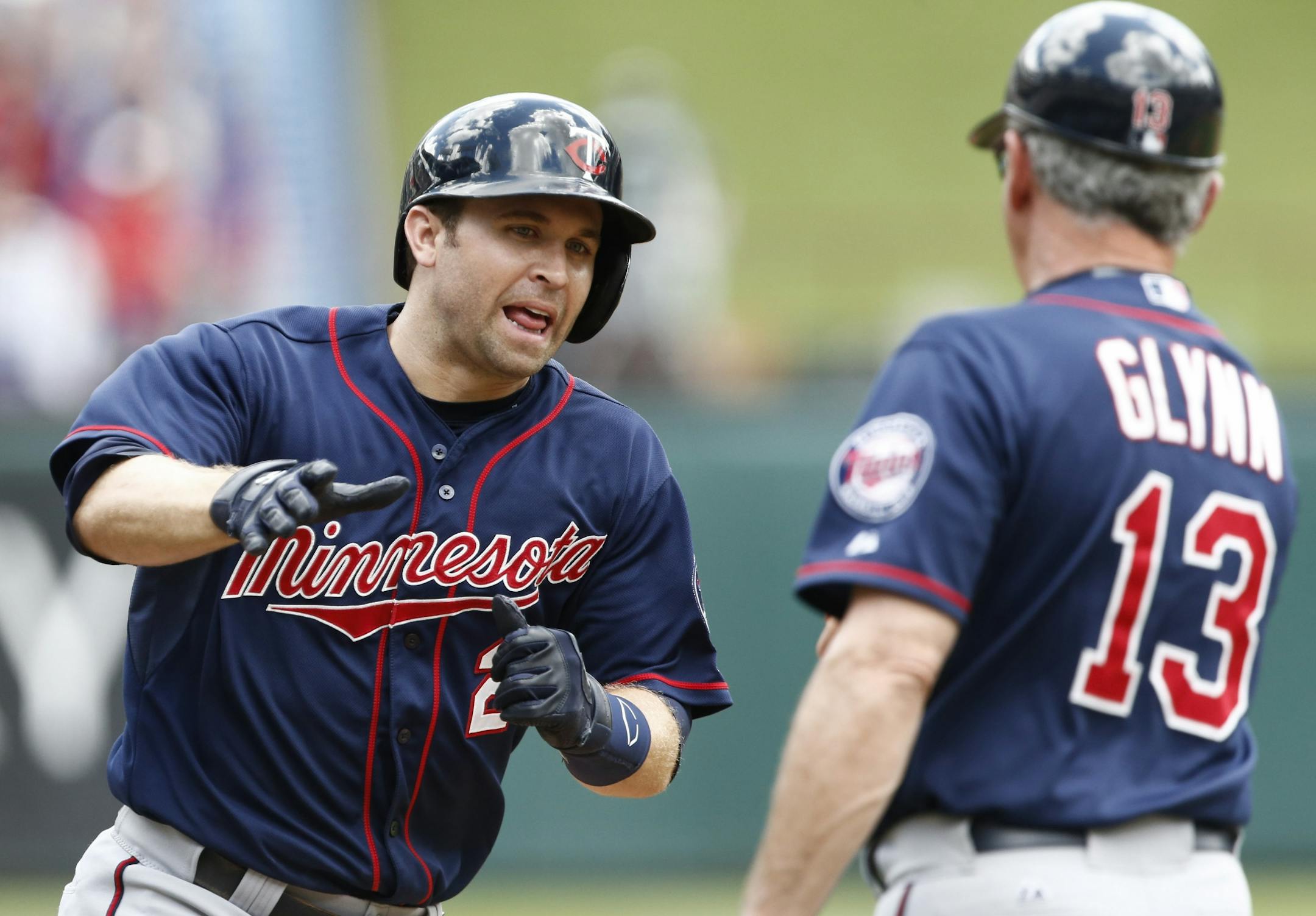Minnesota Twins' Brian Dozier, left, is congratulated by third base coach Gene Glynn (13) on his lead-off home run against the Texas Rangers during the first inning of a baseball game, Sunday, June 14, 2015, in Arlington, Texas.