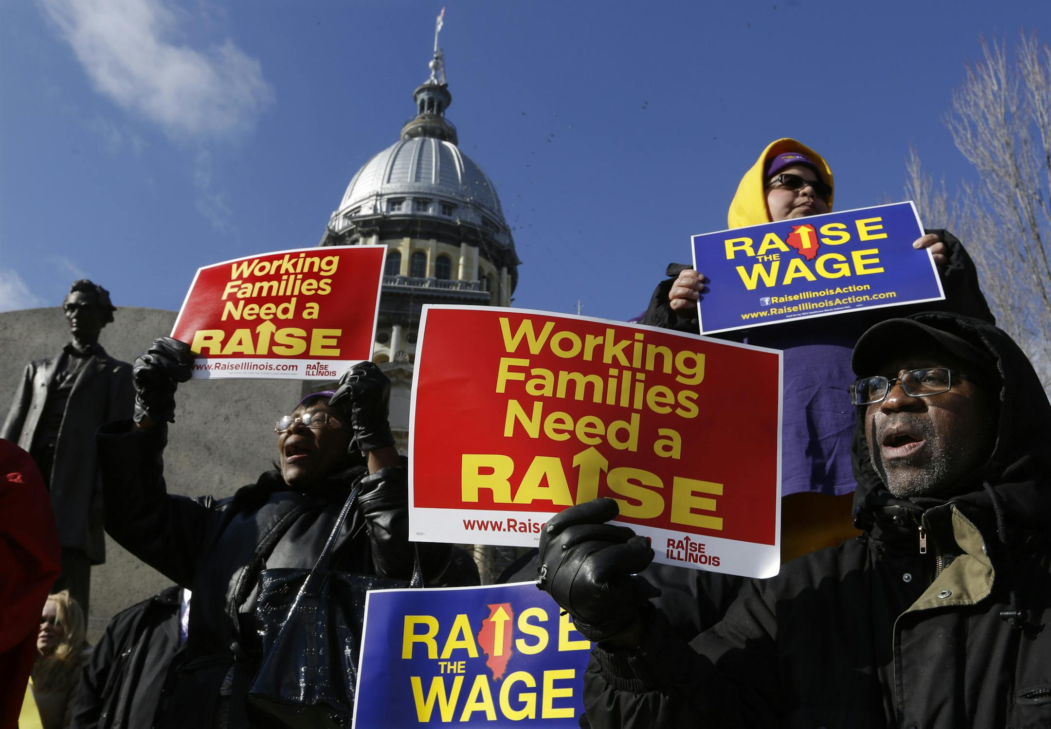 In this Thursday, Nov. 20, 2014 photo, supporters of legislation that will raise the minimum wage in Illinois rally outside the Illinois State Capitol in Springfield Ill. Much is at stake as Republican Gov.-elect Bruce Rauner, who has asked lawmakers not to move major legislation until after he takes office, picks his own loyalists and others to replace Gov. Pat Quinn's people across state government. Illinois has not had a transition from one party to another since Rod Blagojevich took over for