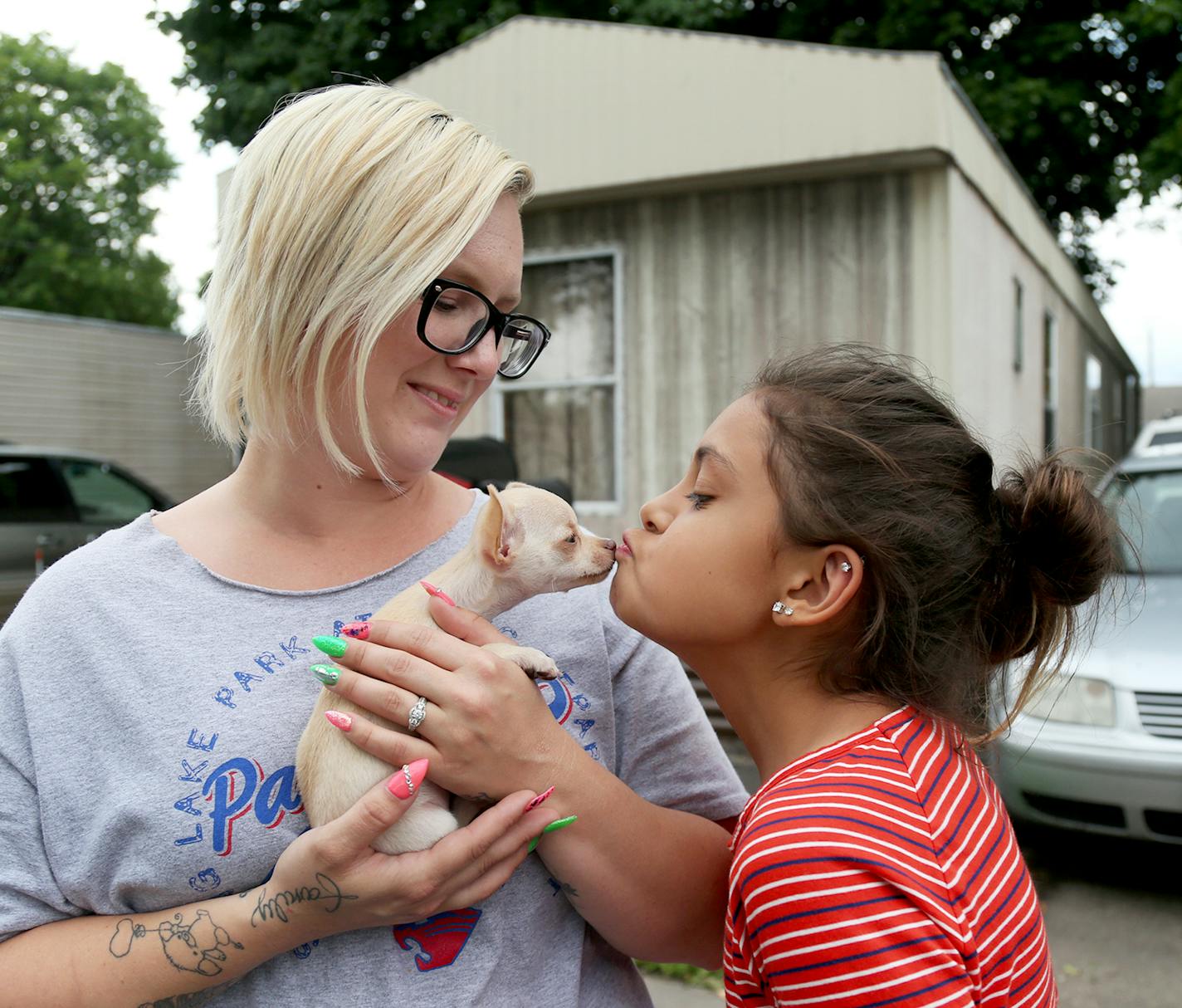 Park Plaza mobile home park residents Rachael Davis, left, watches as her daughter Meadow Loch, 11, kisses their new puppy Val, an eight-week old chihuahua Wednesday, June 28, 2017, in Fridley, MN. Park Plaza has become a thriving cooperative community, owned by its residents and with no threat of closure.] DAVID JOLES &#xef; david.joles@startribune.com It&#xed;s the tale of two parks, with Lowry Grove in St. Anthony and Park Plaza in Fridley providing a case study for the divergent paths mobile