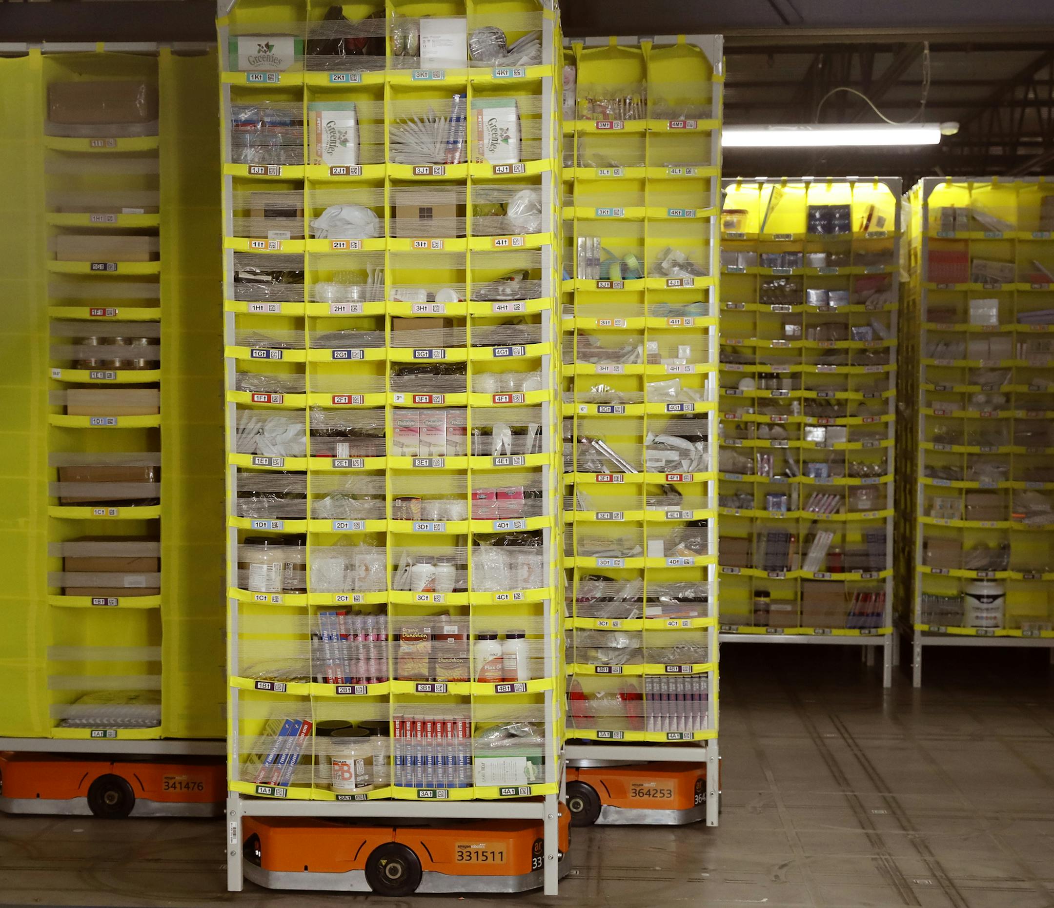 Pods or stgorage bins for items ordered by Amazon customers are controlled robotically by orange "Hercules" drives at an Amazon Fulfillment Center, in Staten Island, Wednesday, June 26, 2019, in New York. The pods are delivered automatically to workstations where Amazon associated fulfil orders.The warehouse, one of the newest in the country, is the size of 14 football fields where 2500 workers arfe employed full time. This particular facility is used a a pilot facility for new technology. being
