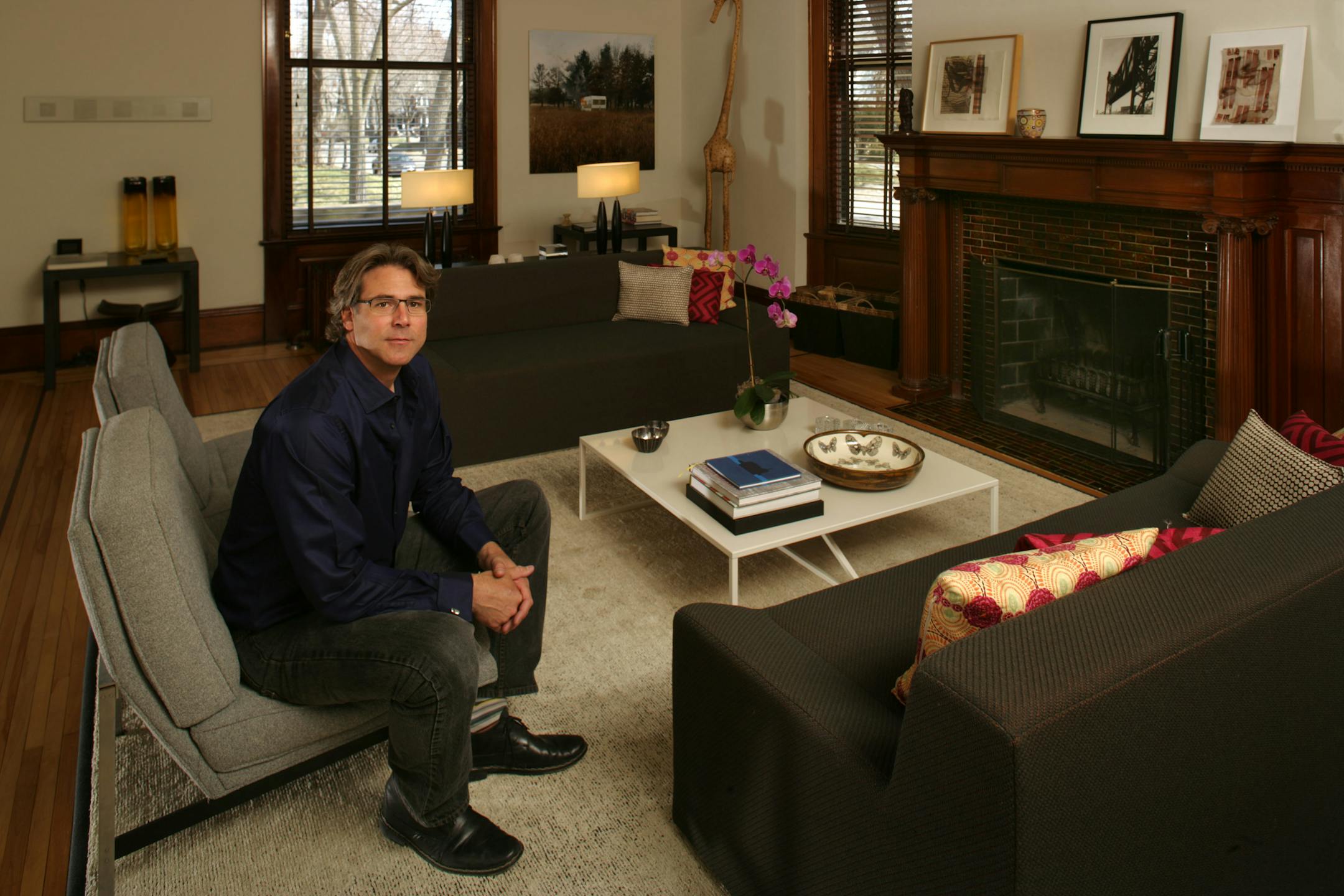 Maurice Blanks, co-founder of Blu Dot, a modernist furniture design company in his Minneapolis living room. The room's decor combines soft textures with splashes of bright colors to make it more visually inviting.