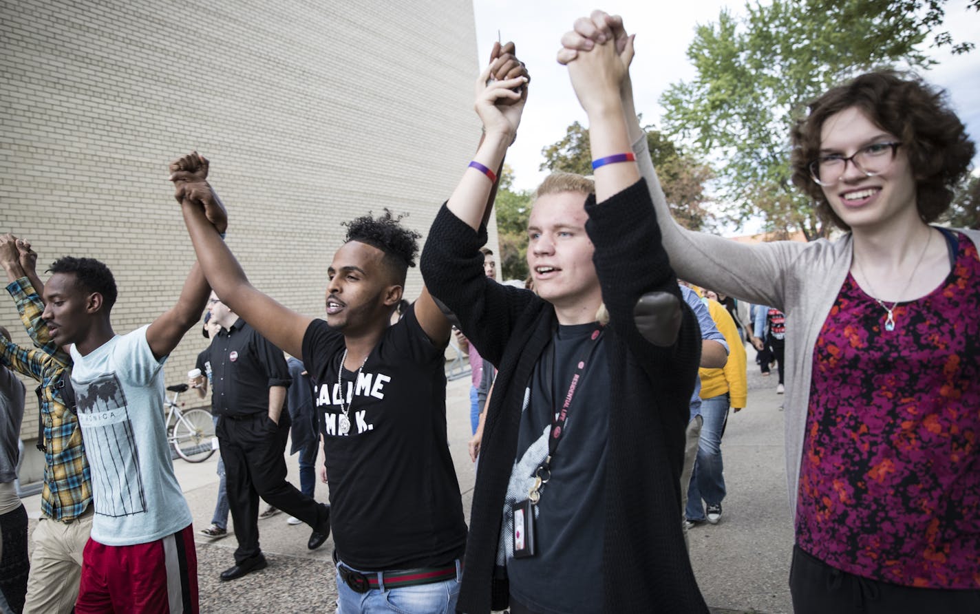 From the left; Najah Ibrahim, Ahmed Kewen, COurtney Kujala and Mathilda Young held hands raised during a unity rally at St. Cloud State University campus in St. Cloud, Minn., on Tuesday, September 20, 2016. ] RENEE JONES SCHNEIDER &#x2022; renee.jones@startribune.com People gathered for Unity march at St. Cloud State University, where Dahir Adan was a student.