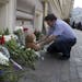 An unidentified man lays a stuffed bear among flowers outside the Dutch embassy in Moscow, Russia, Friday, July 18, 2014. Rescue workers, policemen an