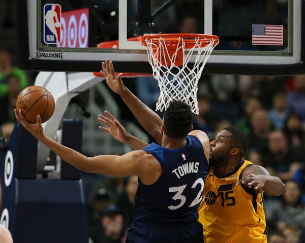 Minnesota Timberwolves center Karl-Anthony Towns (32) shoots while defended by Utah Jazz forward Derrick Favors earlier this month. The NBA playoffs b