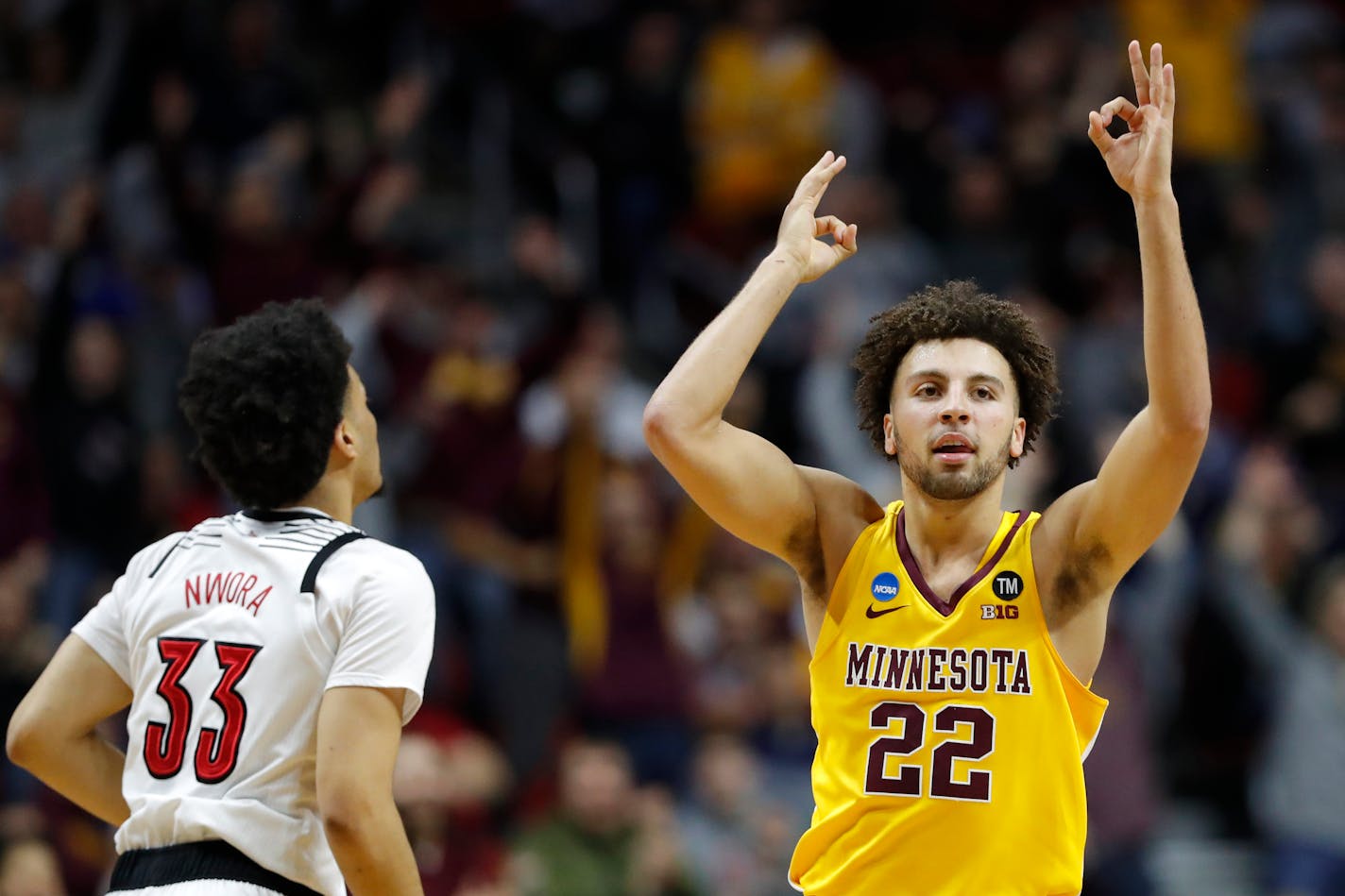 Gophers guard Gabe Kalscheur celebrates in front of Louisville forward Jordan Nwora after making a three-point basket during the first round