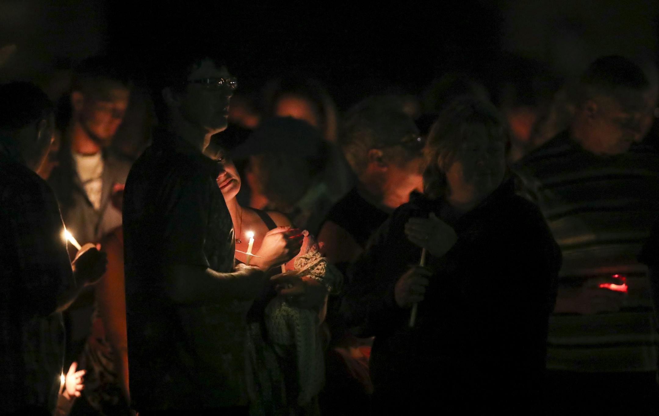 Matt and Kayla, the parents of Alayna Ertl, stood with their lit candles during the prayer vigil for their daughter Tuesday night in the parking lot of St. Anthony Church in Watkins.