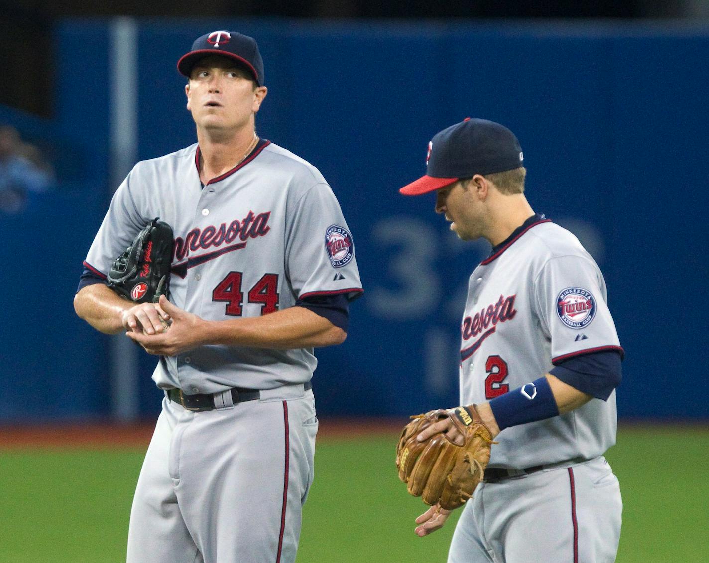 Minnesota Twins starting pitcher Kyle Gibson stands on the mound with teammate Brian Dozier after giving up four runs to the Toronto Blue Jays during the fifth inning of a baseball game Thursday, Aug. 6, 2015, in Toronto. (Fred Thornhill/The Canadian Press via AP)