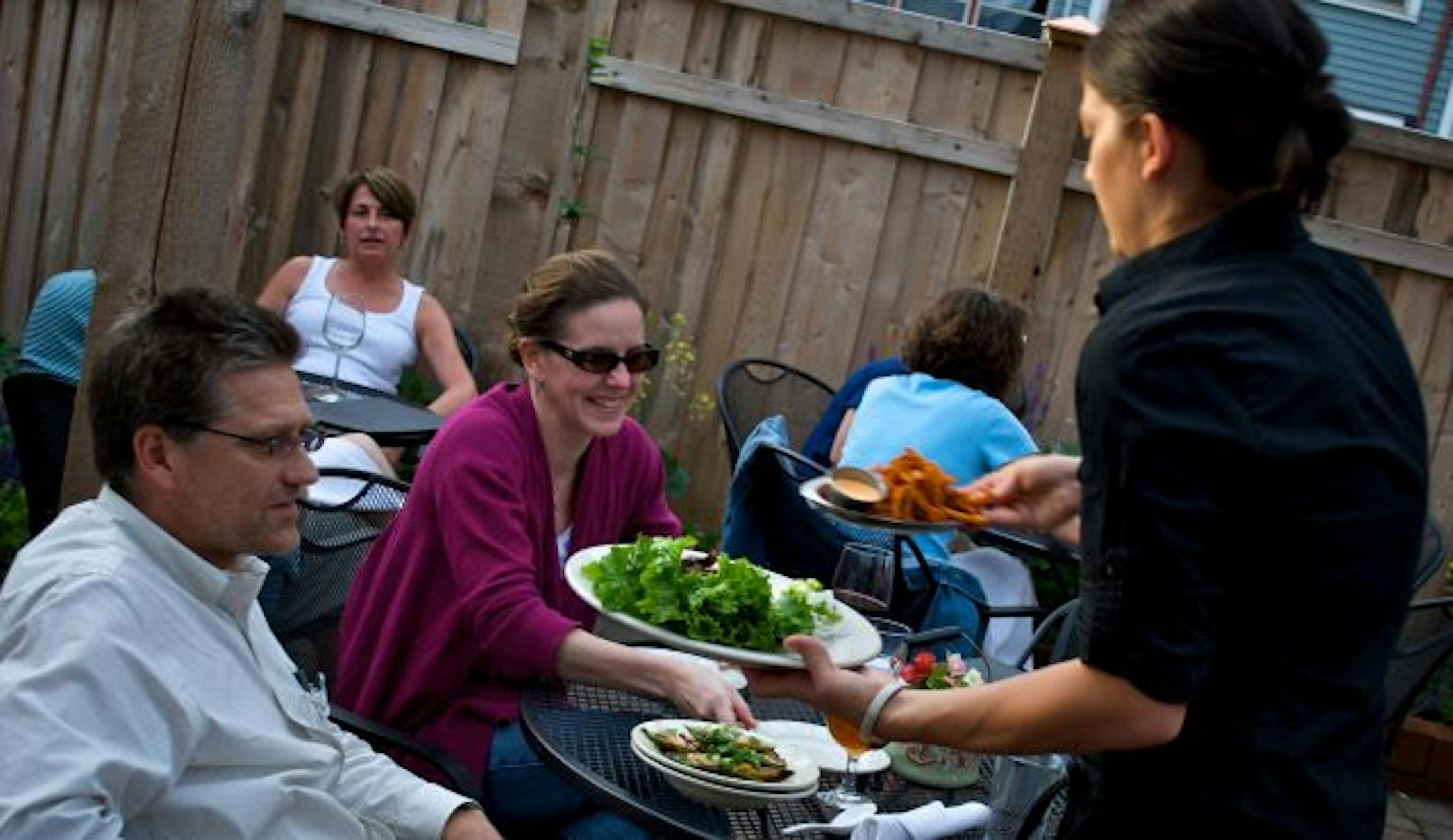 T.J. Reinartz and Denise Rahne from St. Paul, enjoy patio dining at the Ngon Vietnamese Bistro in St. Paul. Leslie Hoffman brings them their dinner order. Owner Hai Truong uses local sources for the dishes the restaurant prepares.