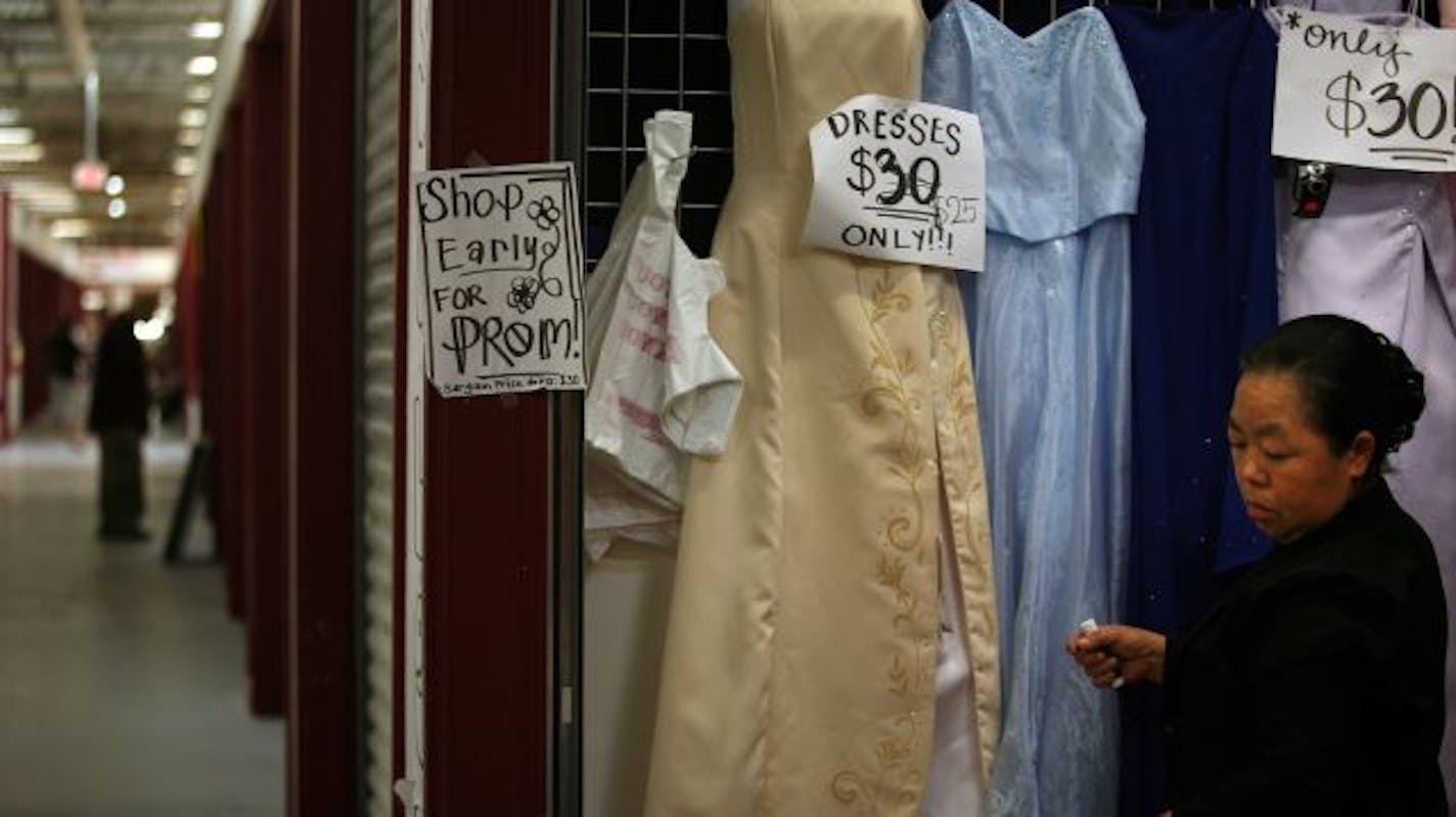 Volunteer from the House of God church, Xang Thao checked the price tags on clothes as she waited for customers at the Hmong Village in East St. Paul at the end of the month. Hmong Village donated this booth for churches who want to raise money.