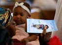 A woman holds a program at a celebration of life service for Le'Vonte King Jason Jones, 2, shot and killed last week in a drive-by shooting, during a 